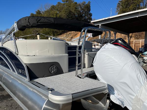 2025 Harris Cruiser 230 pontoon boat with covered engine, docked outdoors.