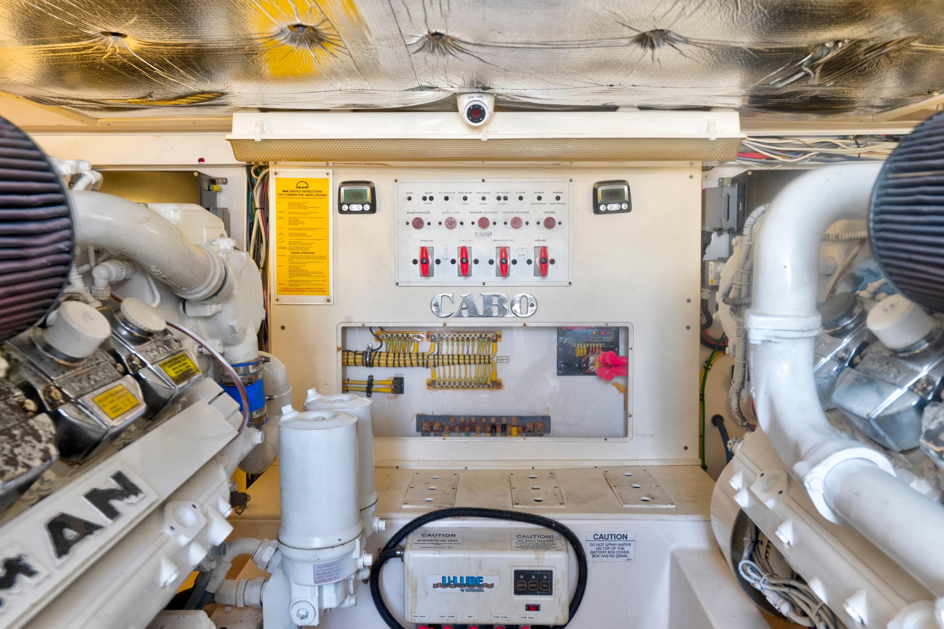 Engine room of 2010 Cabo 45 Express boat, featuring control panel and machinery.