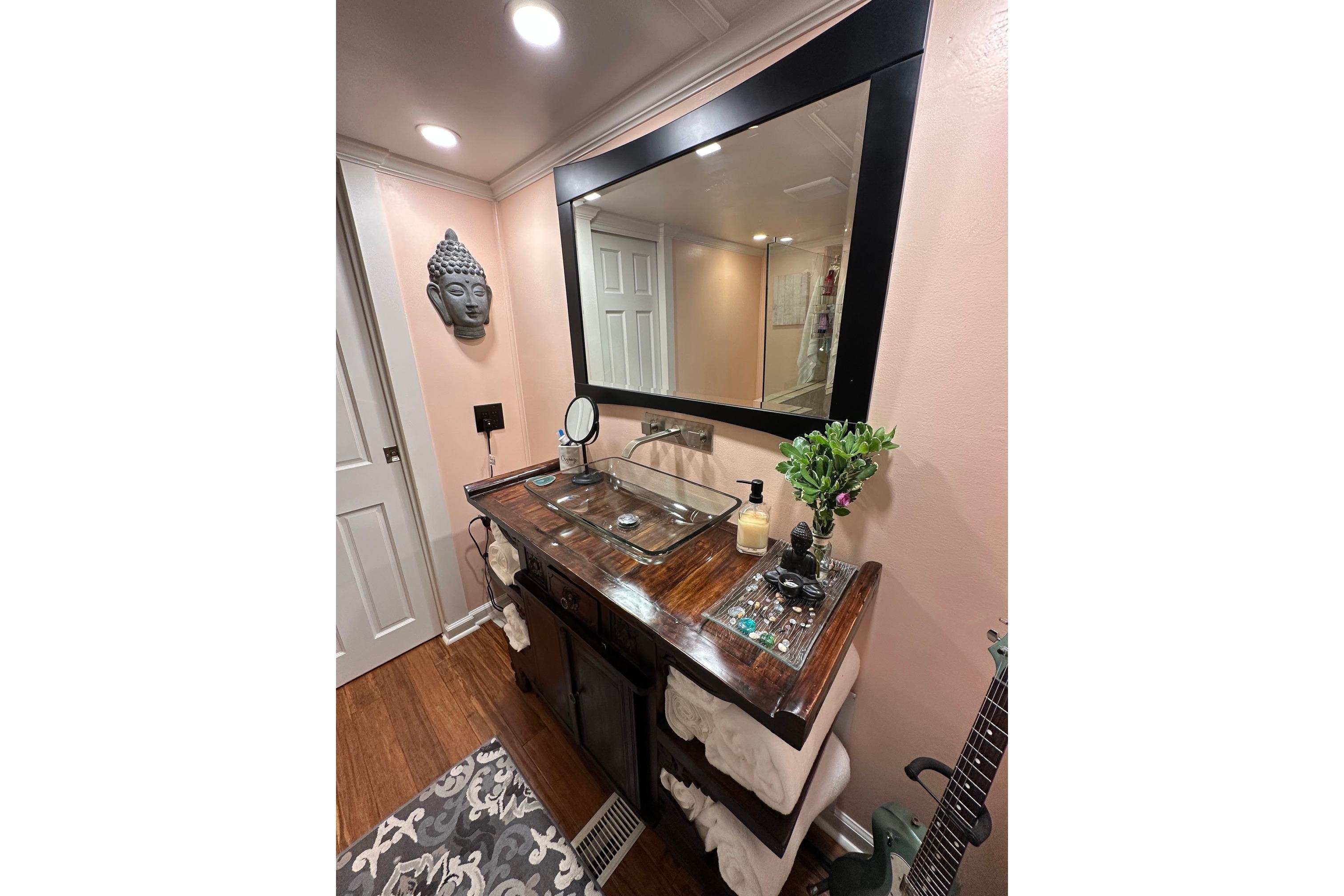 Elegant bathroom vanity with large mirror, Buddha decor, and wooden countertop in a 1993 Lazy Days 16x65.