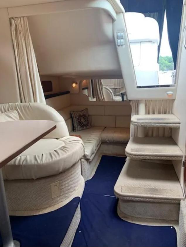 Interior of 2002 Sea Ray 340 Sundancer yacht with cozy seating and stairs.