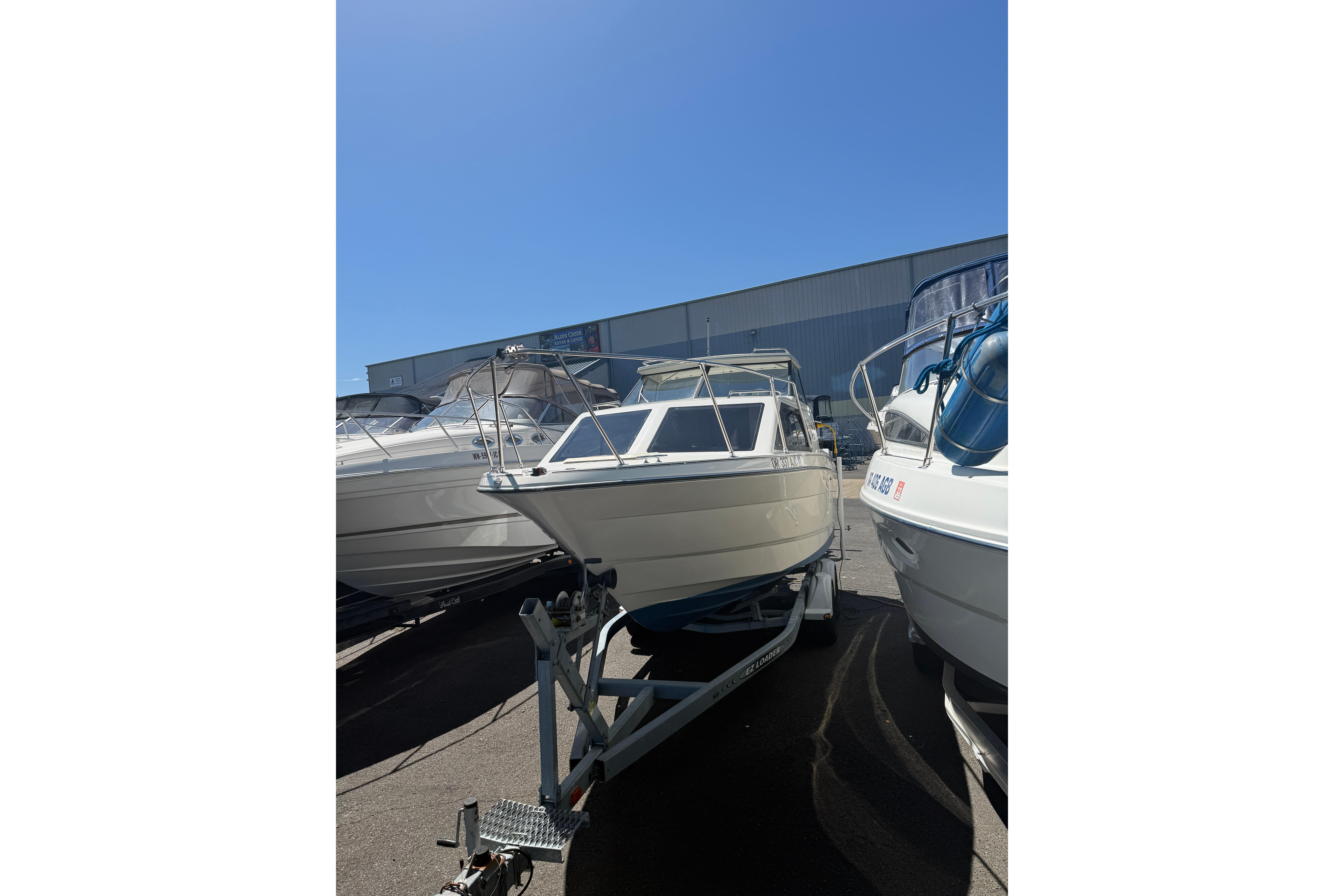 1997 Bayliner 2452 Ciera Express boat on trailer under clear blue sky.