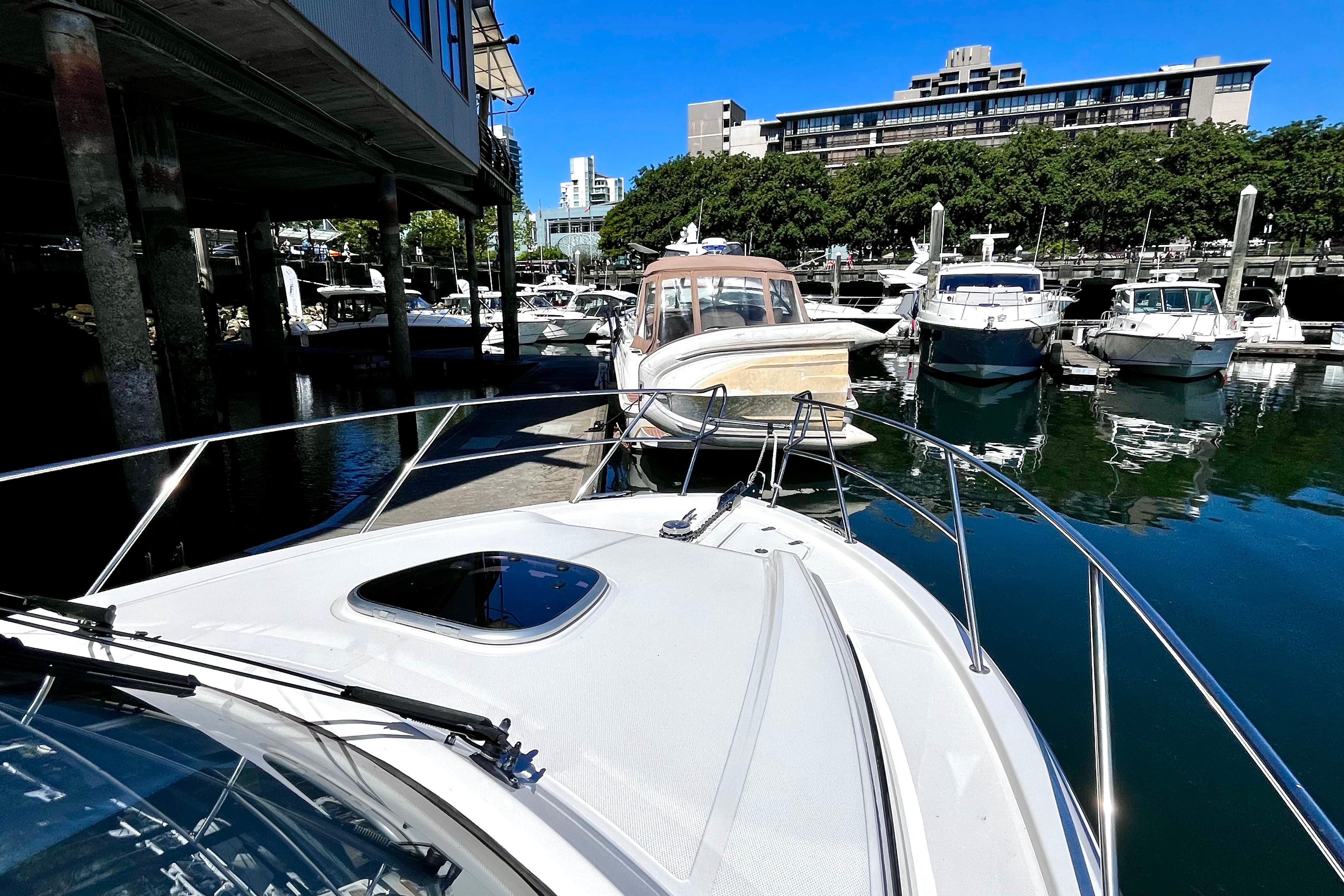 Boston Whaler 325 Conquest Pilothouse 2026 docked in a marina with other boats.