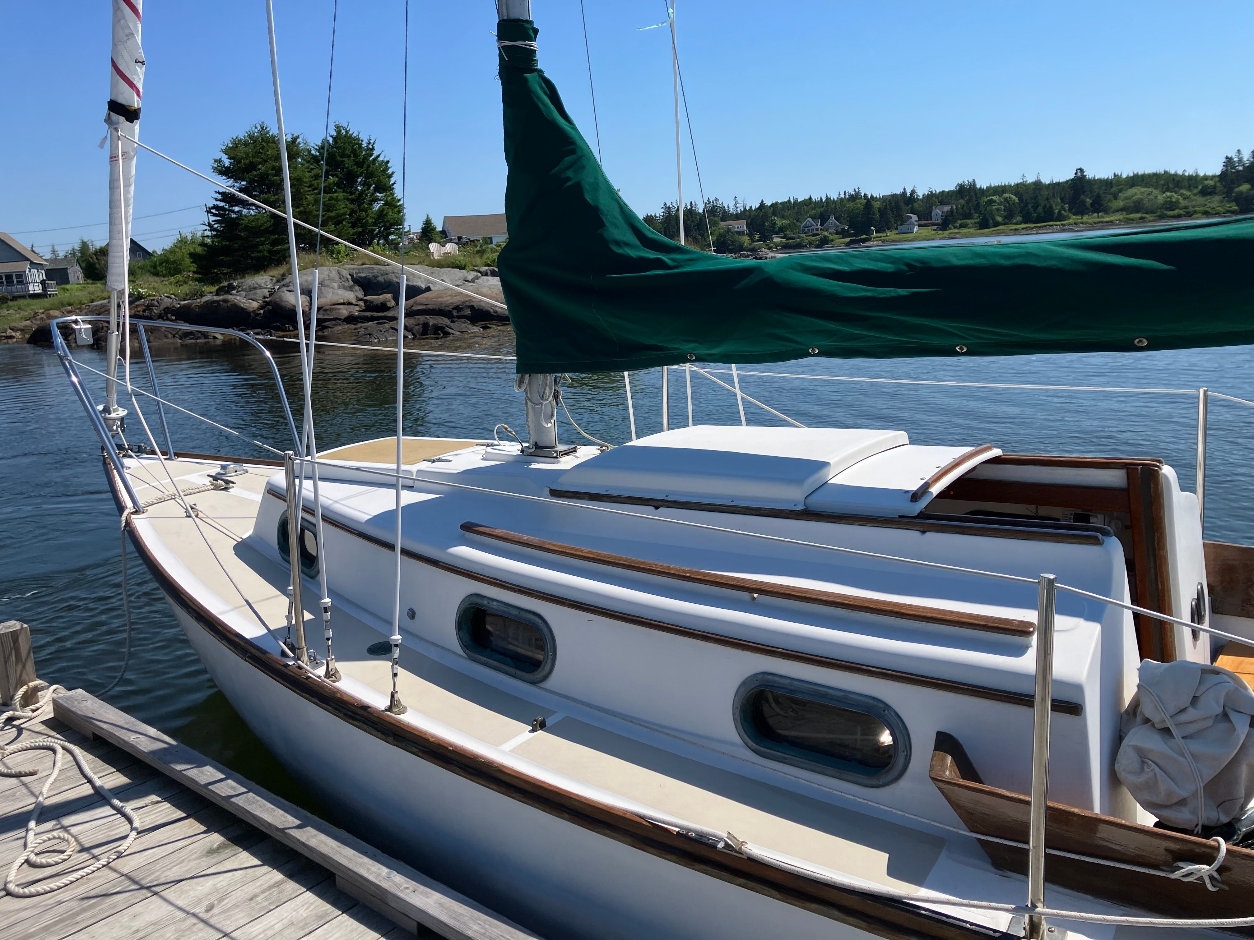 A 1982 Cape Dory 25 sailboat docked in a calm setting.