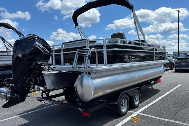 2026 Sun Tracker Fishin' Barge 20 DLX pontoon boat on trailer, parked outdoors.