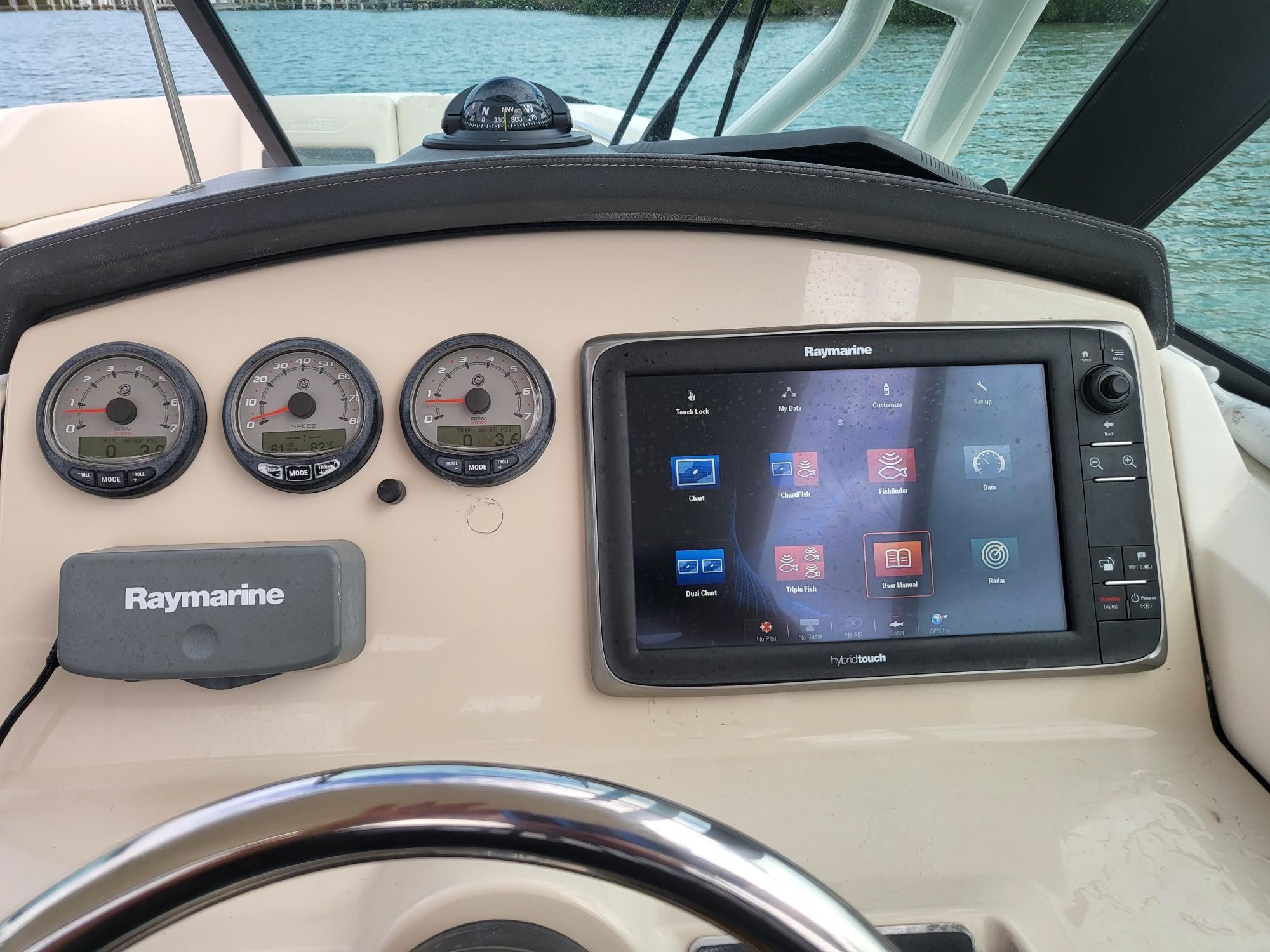 The dashboard of a boat with Raymarine screen and instruments.