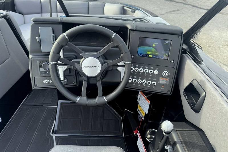 2026 Moomba Tykon boat dashboard with steering wheel and digital display.
