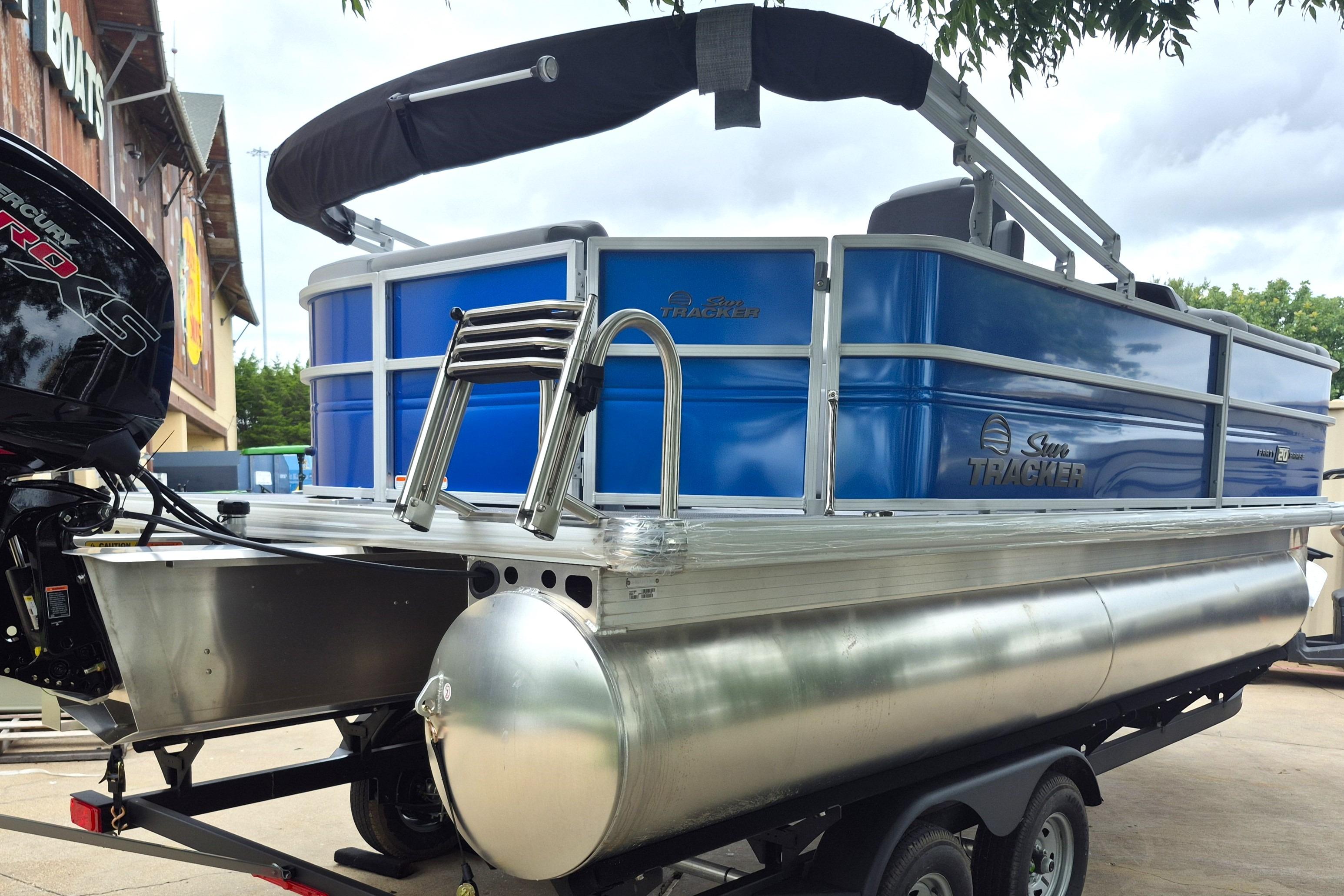 2026 Sun Tracker Party Barge 20 DLX pontoon boat with blue exterior on trailer.