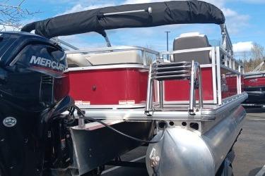 2026 Sun Tracker Bass Buggy 18 DLX pontoon boat with Mercury engine, docked outdoors.