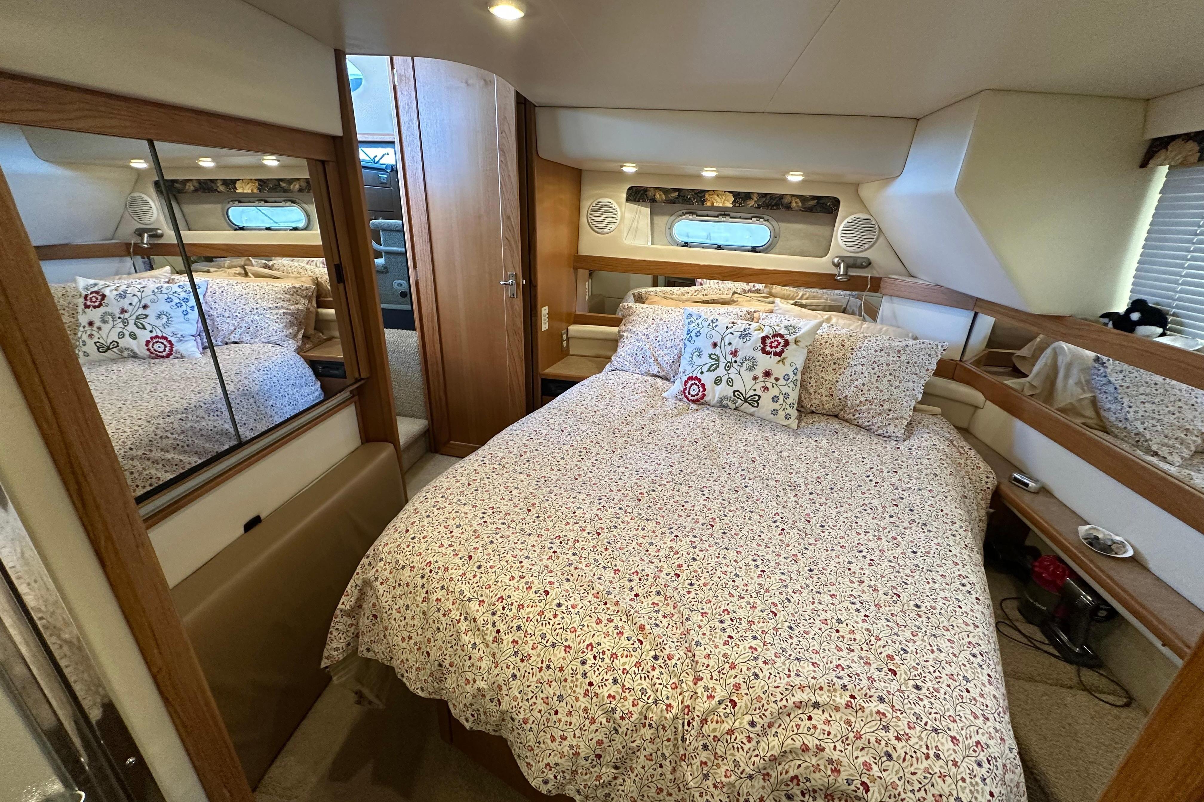 Cozy bedroom in 2000 Bayliner 4087 Aft Cabin Motoryacht with floral bedding and wood accents.