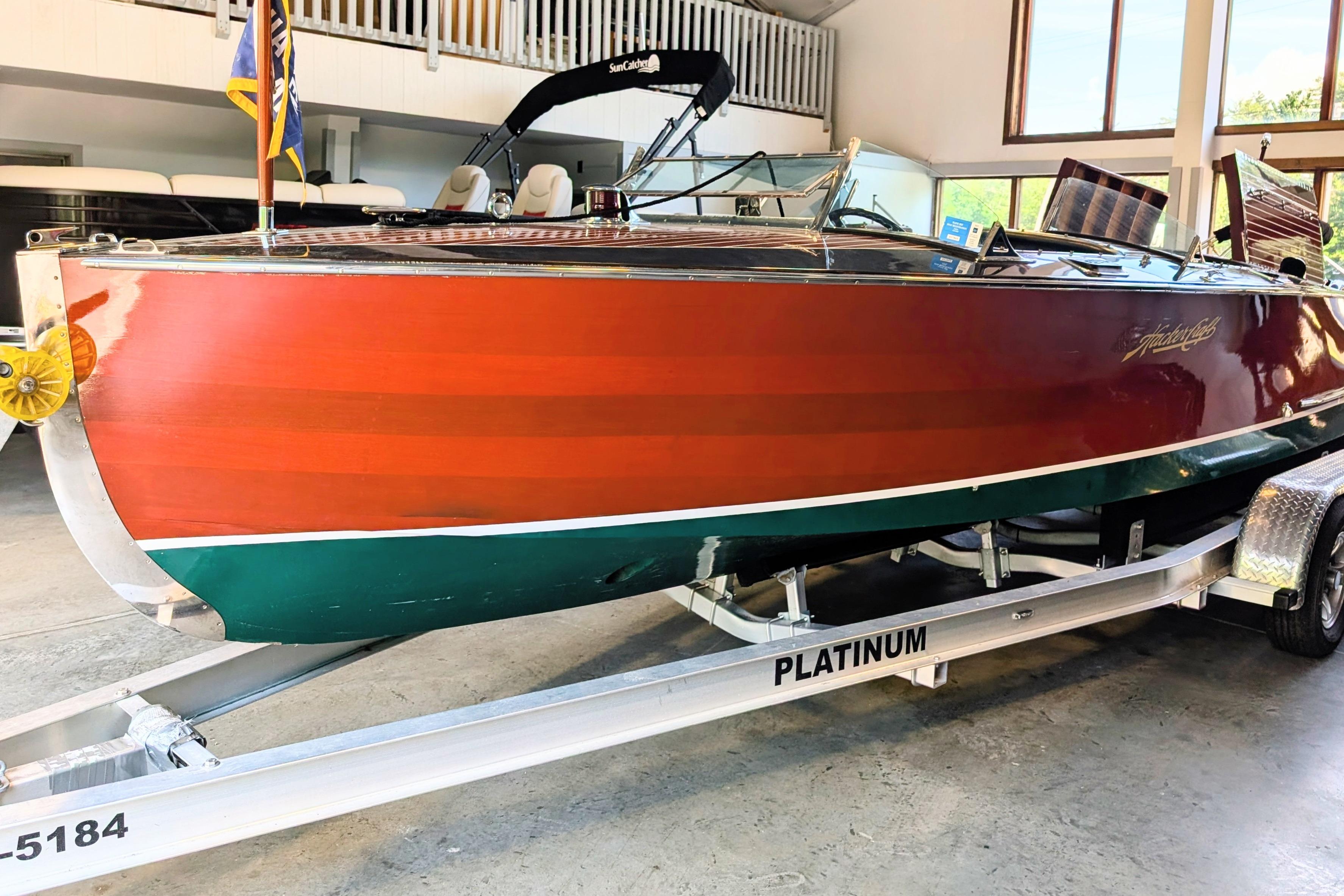 2001 Hacker-Craft 24 Dual Console boat on trailer in indoor showroom.