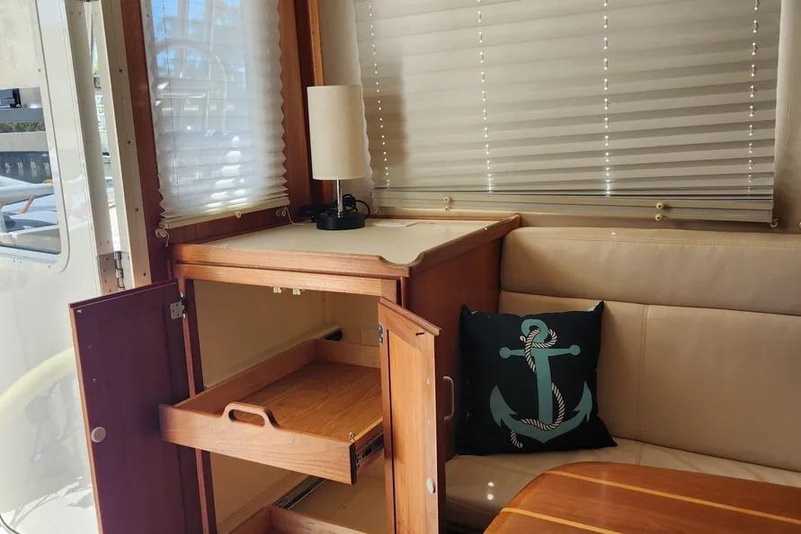 Interior of 2006 American Tug AT with wooden cabinet, anchor pillow, and blinds.