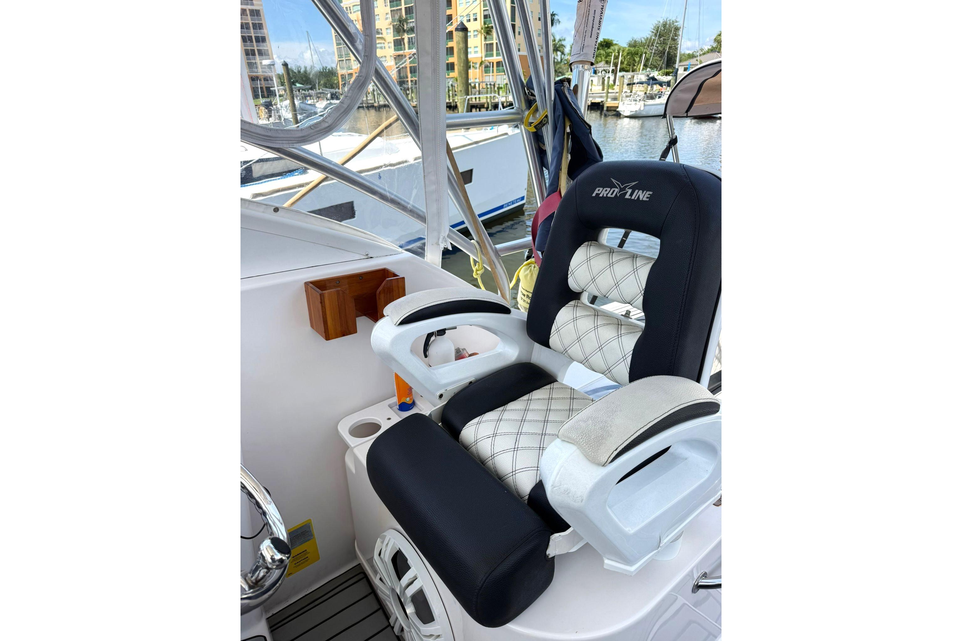 Captain's chair on 2006 Pro-Line 32 Express boat, docked at marina.