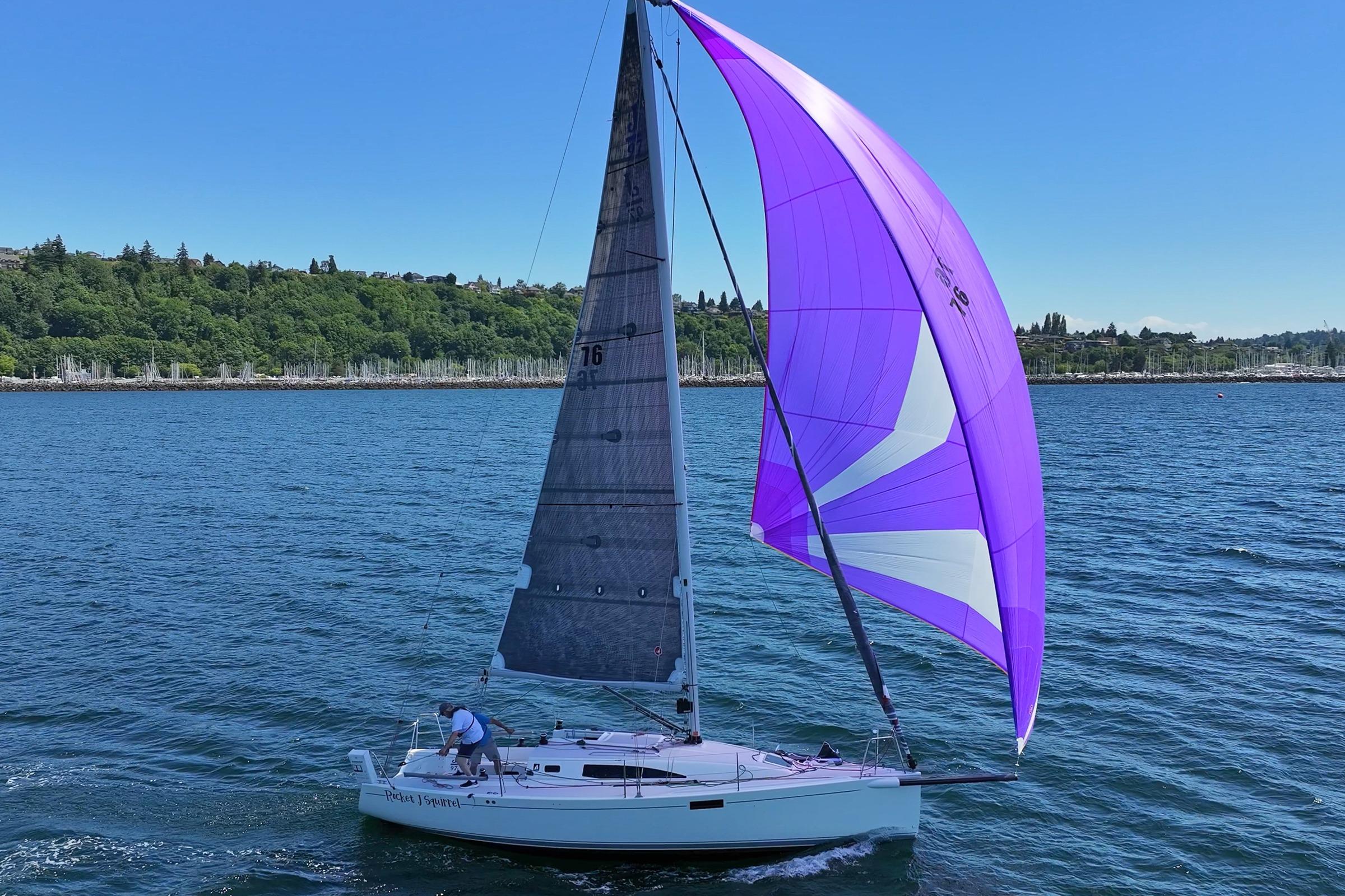 2018 J Boats J/97E sailing with vibrant purple spinnaker on a sunny day.