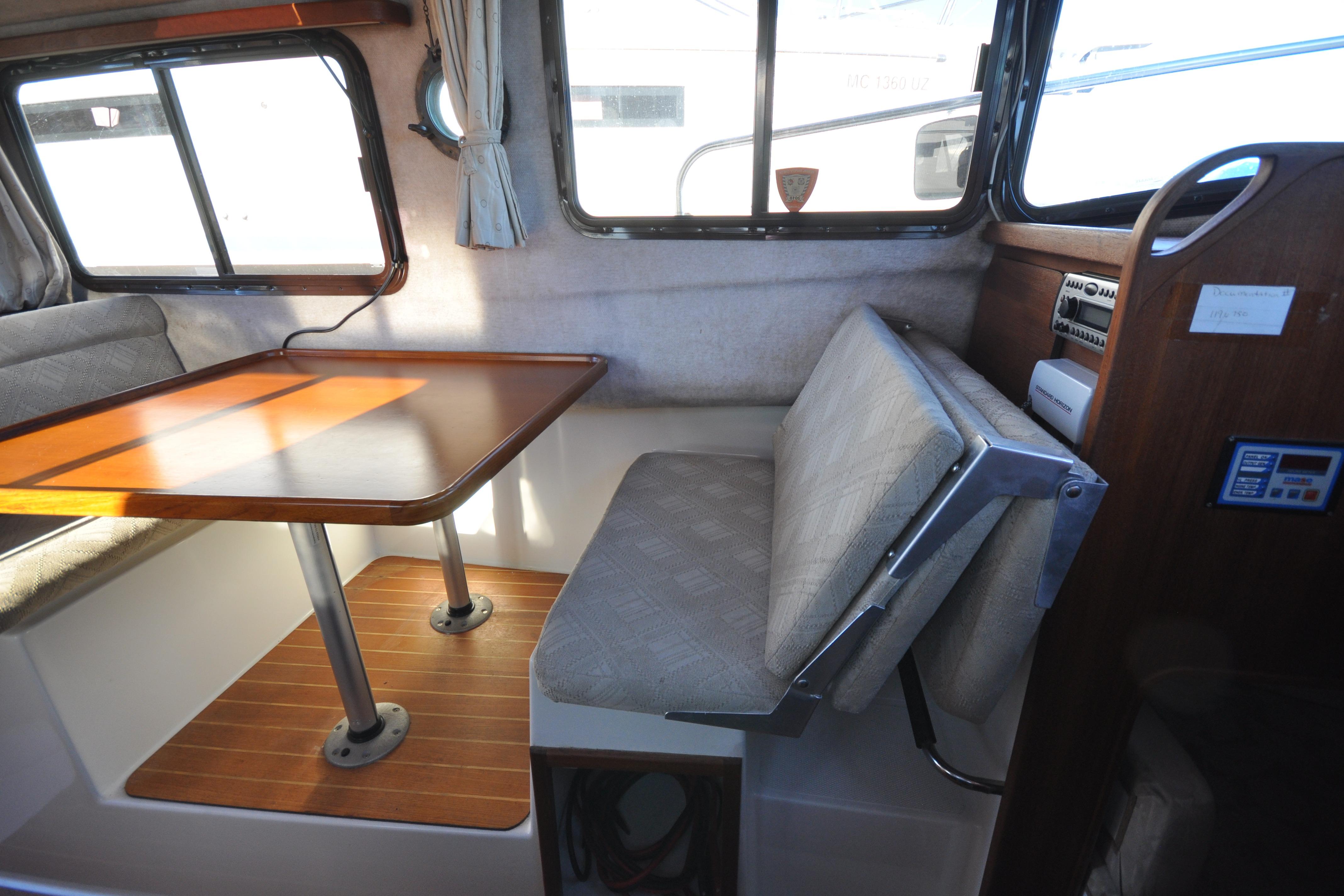 Interior of 2007 Ranger Tug R-25, featuring a cozy dining area with wooden table.