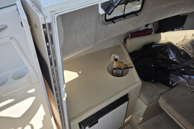2004 Robalo R235 Walkaround cabin interior with seating and storage area.