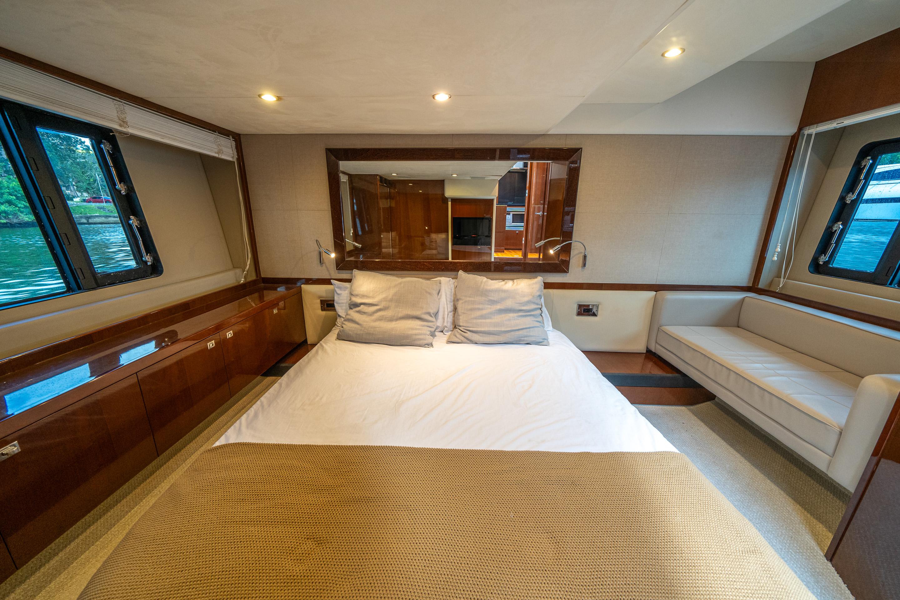 Luxurious bedroom interior of 2012 Princess V52 yacht with elegant furnishings and large windows.