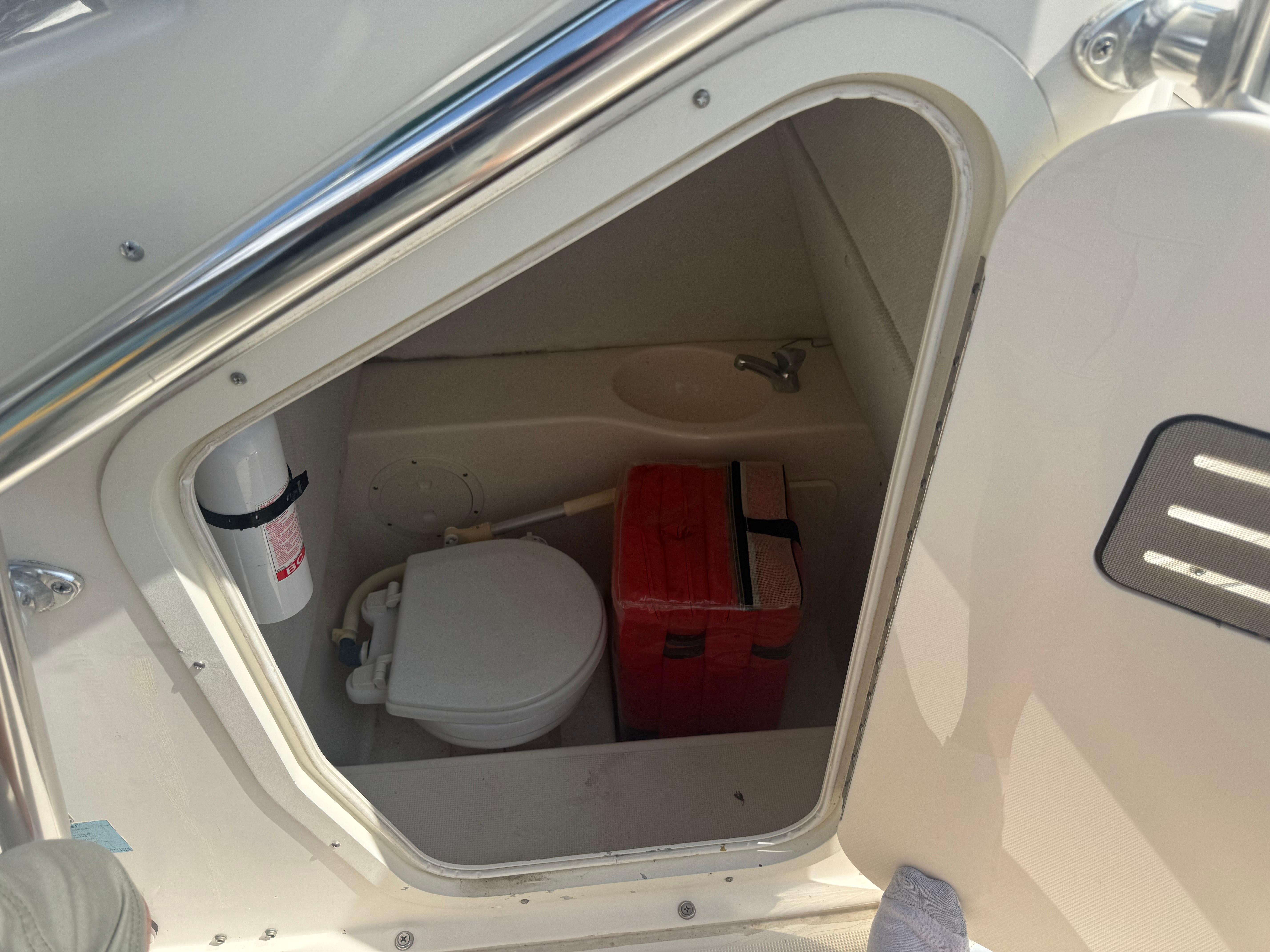 2002 Pursuit 2470 CC boat interior with toilet and storage compartment.
