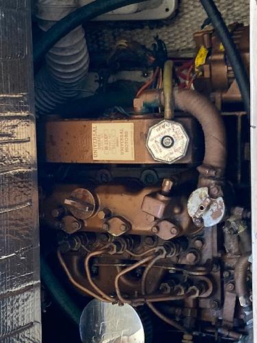 Engine compartment of a 1989 Catalina 30 sailboat, showcasing mechanical components and wiring.
