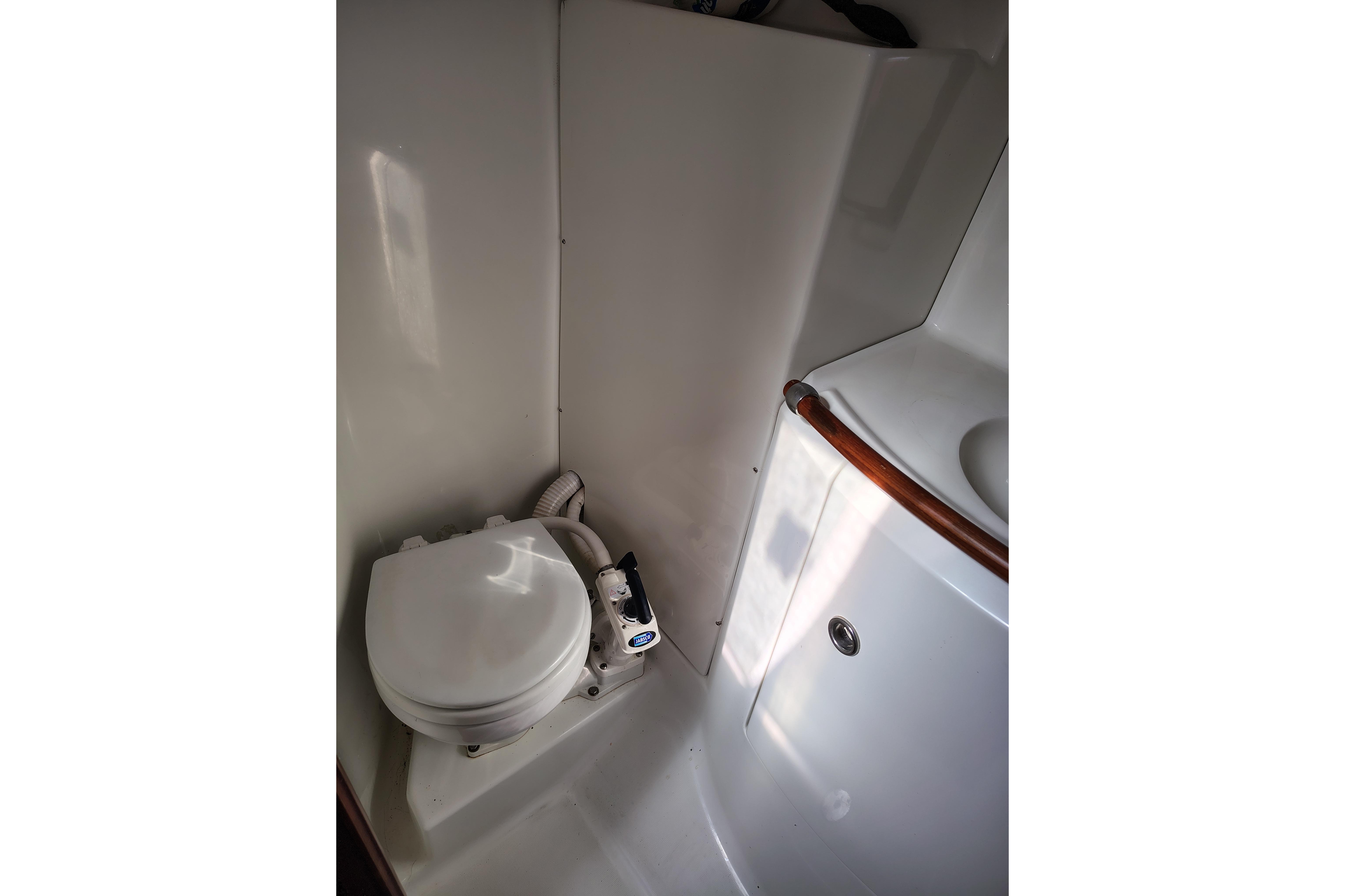 Bathroom interior of 2001 Beneteau Oceanis 411 yacht, featuring toilet and sink.
