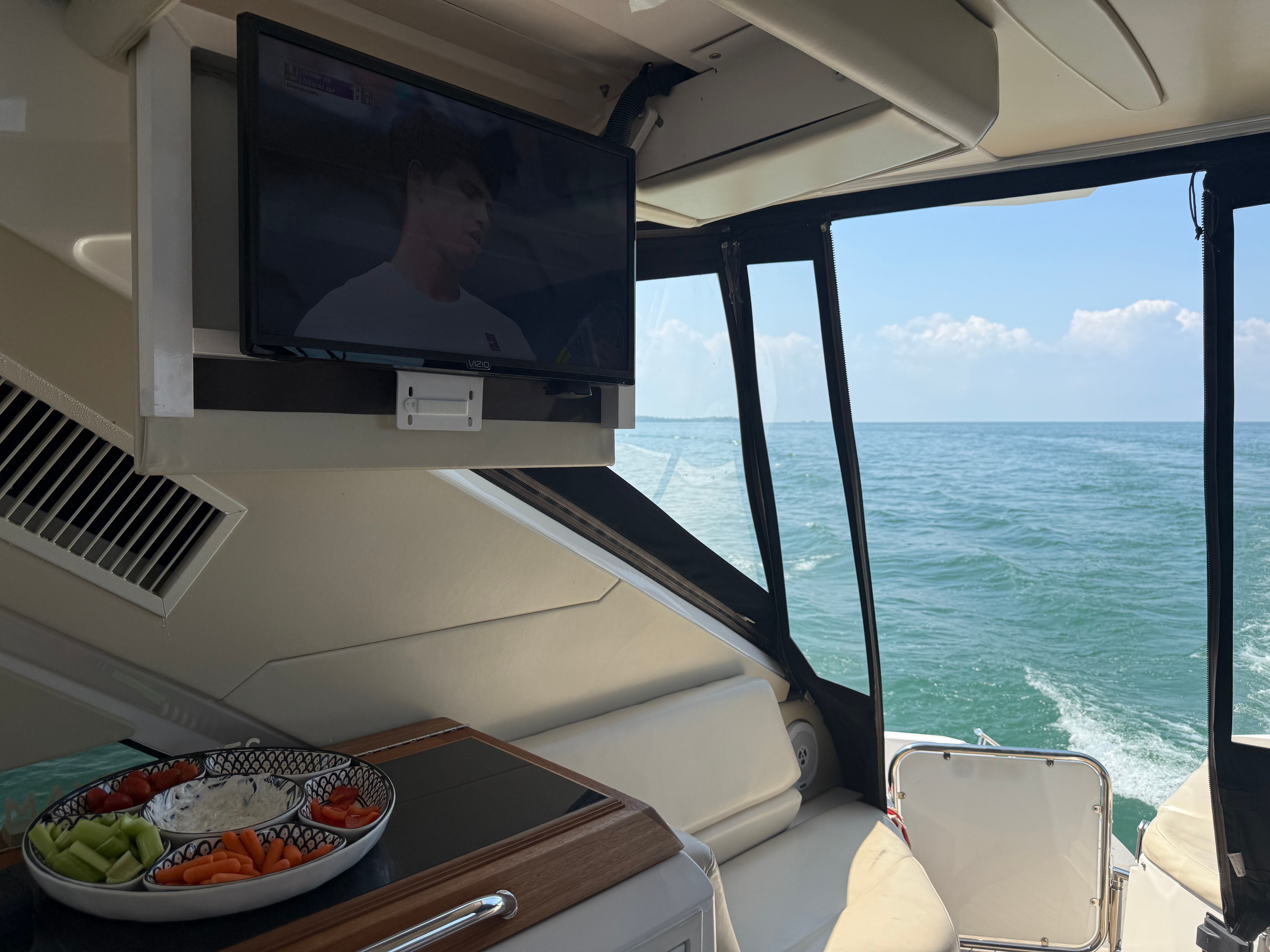 Interior of a Regal 52 Sport Coupe yacht with TV and snack platter.
