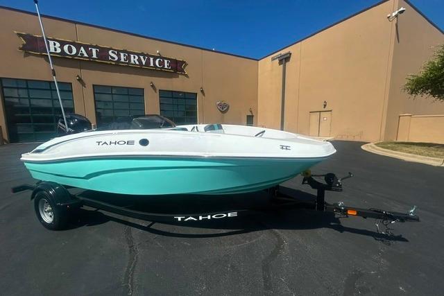 2026 Tahoe T16 boat in mint green, parked outside a boat service center.