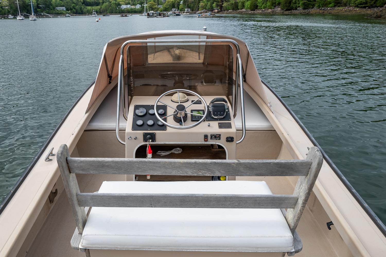 1989 Ellis 24 Open boat interior with steering wheel, dashboard, and lake view.
