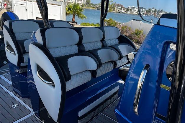 2022 Nor-Tech 390 Sport Center Console with luxurious seating, docked by waterfront homes.
