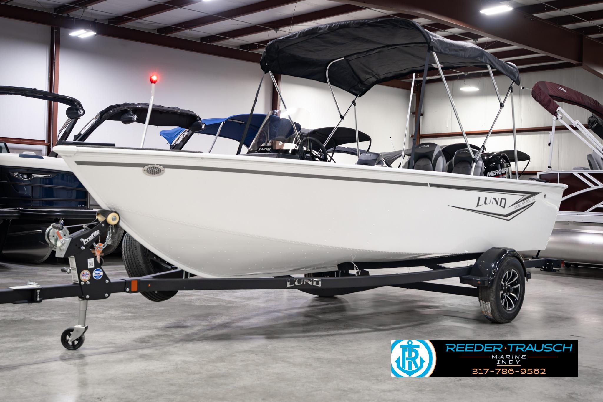2026 Lund 1650 Rebel XL SS boat on trailer in showroom, featuring canopy and sleek design.