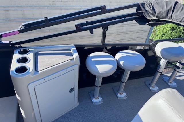 2022 Sylvan L3 DLZ Bar boat interior with bar stools and cup holders.