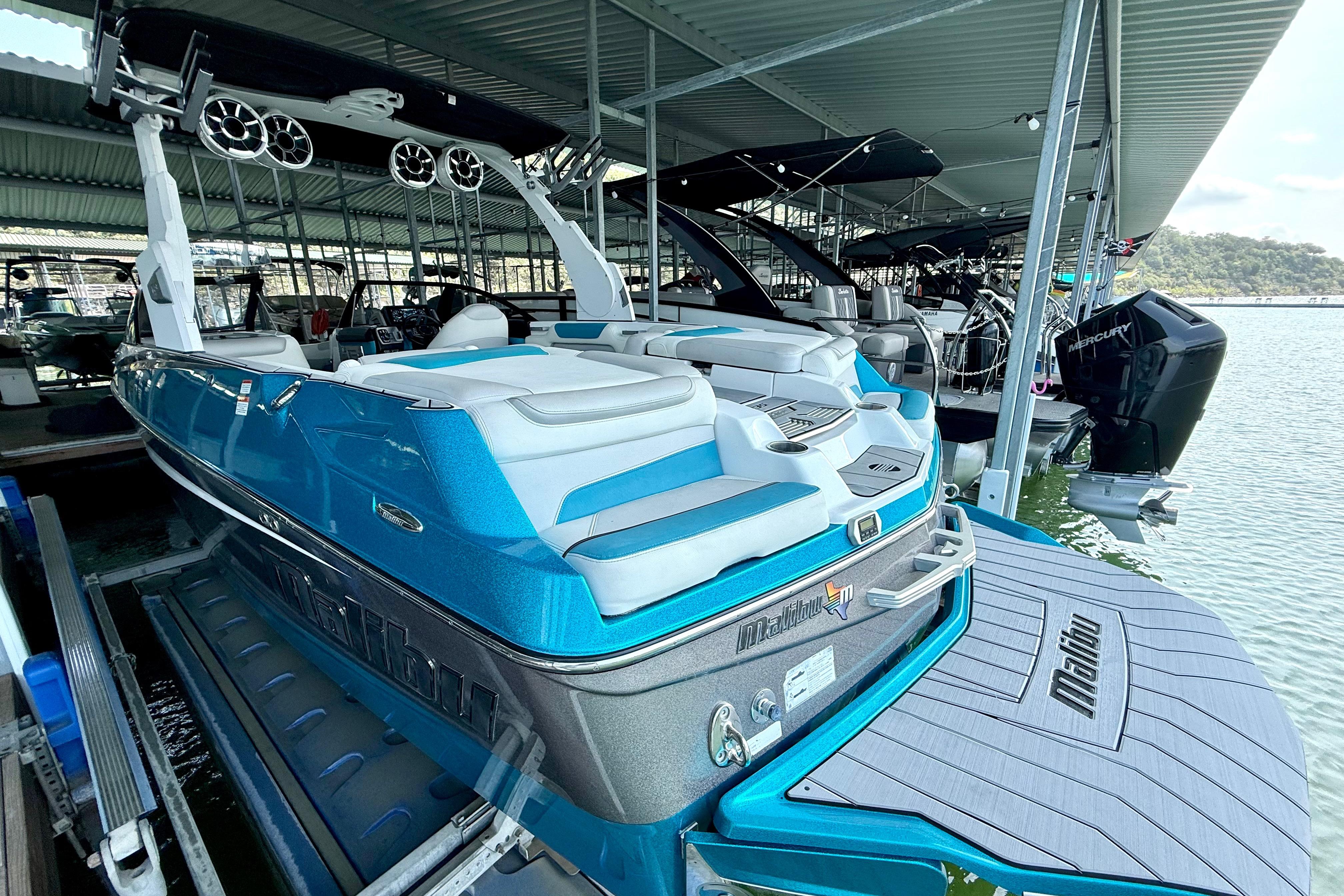 2017 Malibu M235 boat docked, featuring sleek blue design and modern amenities.