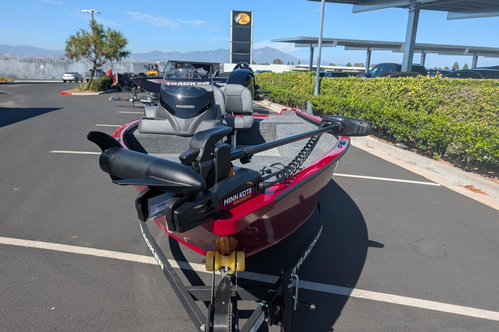 2026 Tracker Super Guide V-16 SC boat with Minn Kota motor in parking lot.