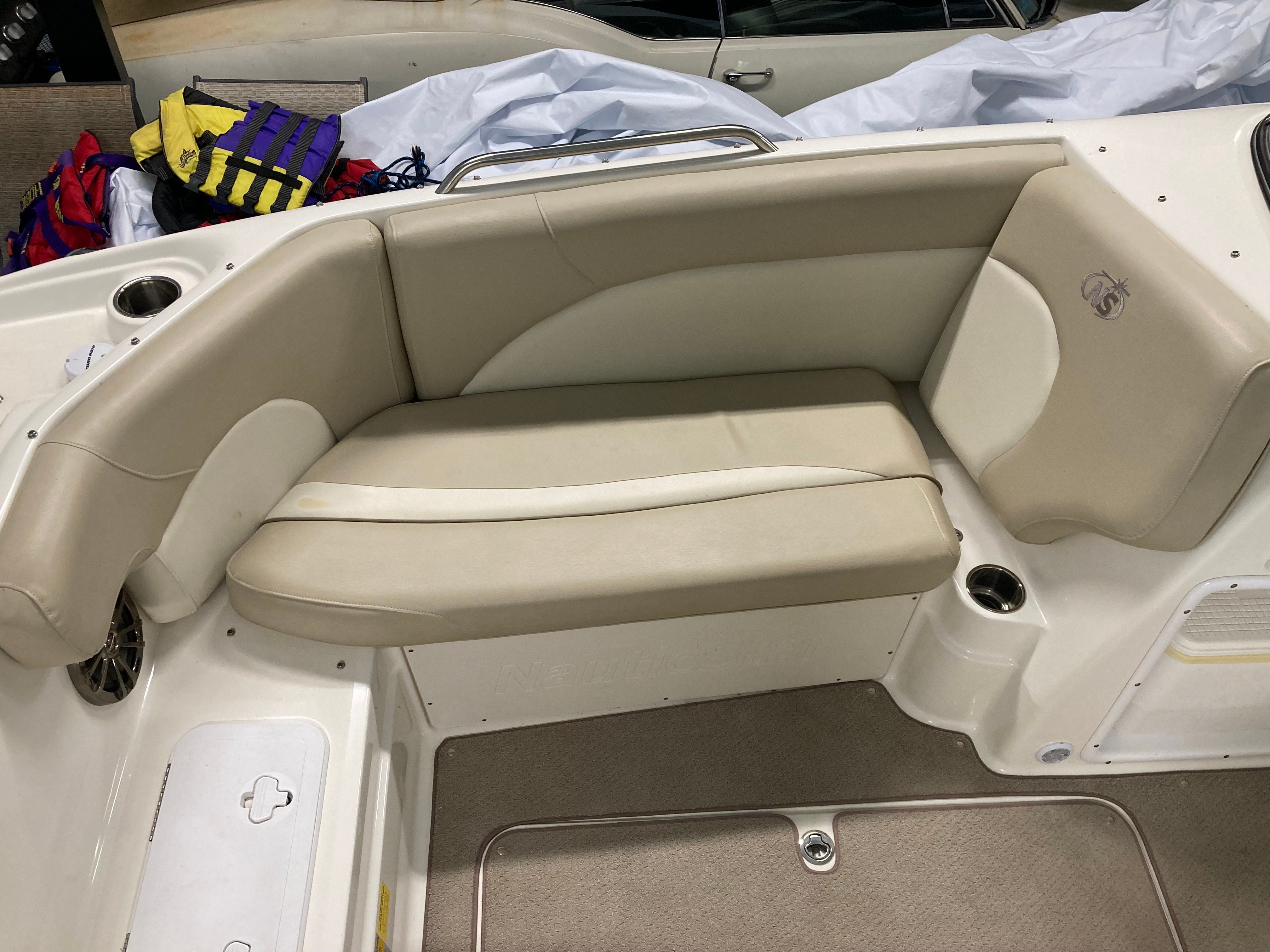 Interior view of a boat with beige seating area and cup holders.