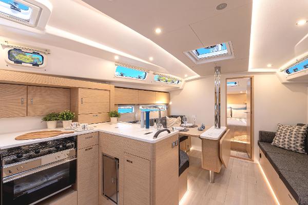Luxurious interior of 2025 Hanse 360 yacht with modern kitchen and seating area.