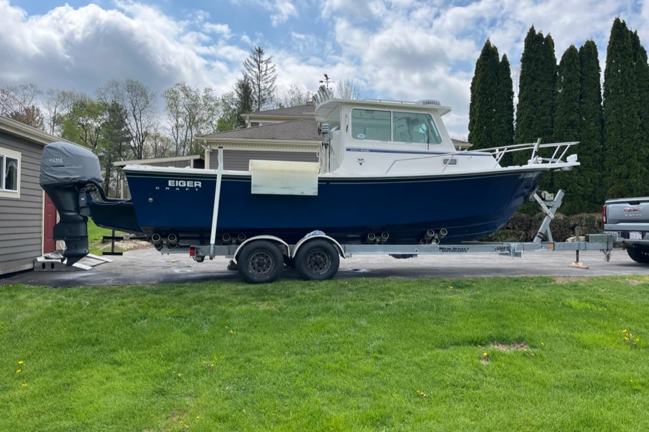 2012 Steiger Craft Miami boat on trailer, parked in driveway, surrounded by greenery.
