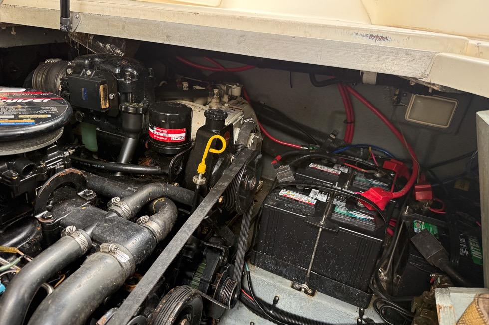 Engine compartment of a 1999 Sea Ray 290 Sundancer with visible batteries and wiring.