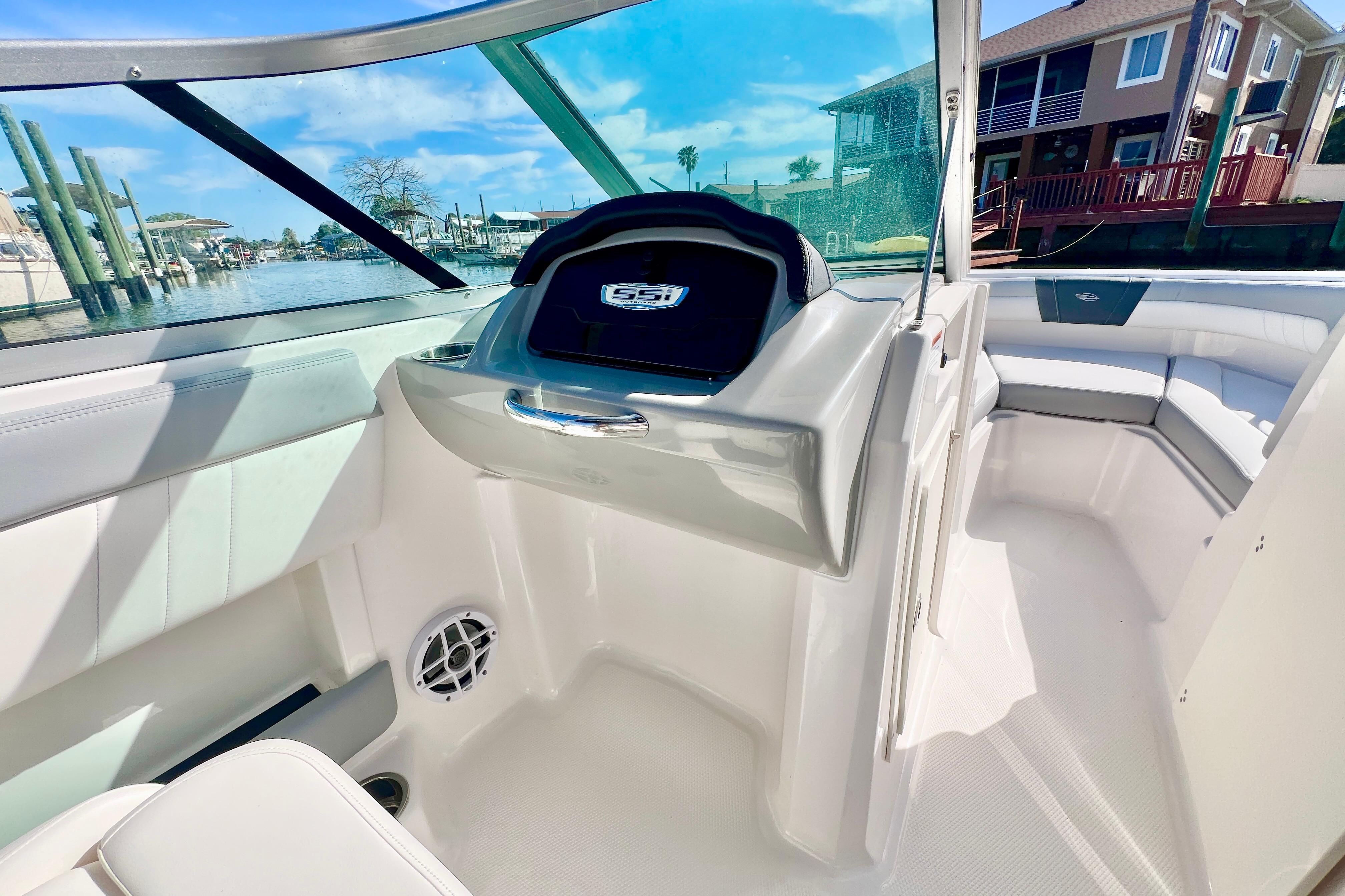 2023 Chaparral 21 SSi OB boat interior with seating and dashboard, dockside view.