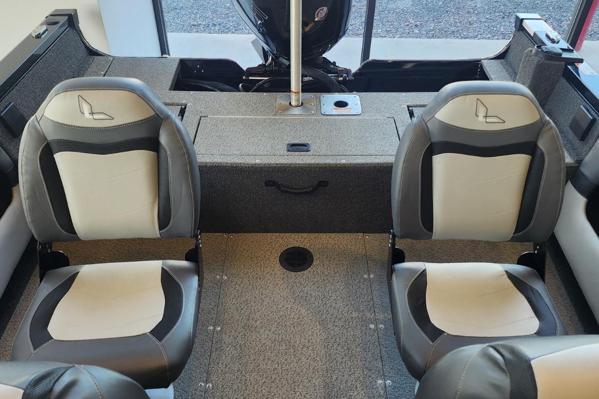 2023 Lowe boat interior with two gray and white seats, carpeted flooring, and motor area.