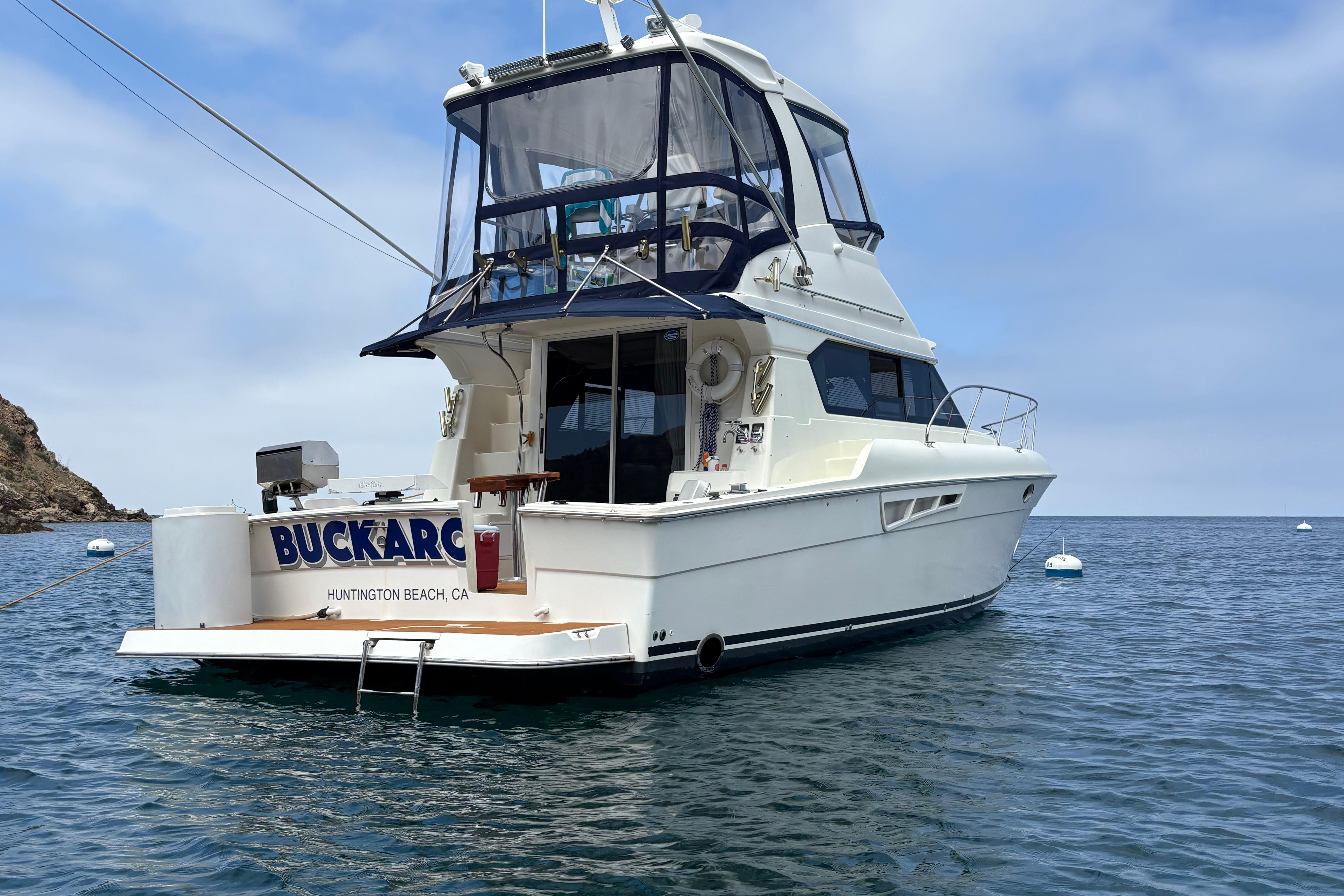 2000 Silverton 42 Convertible yacht anchored in calm waters, Huntington Beach, CA.