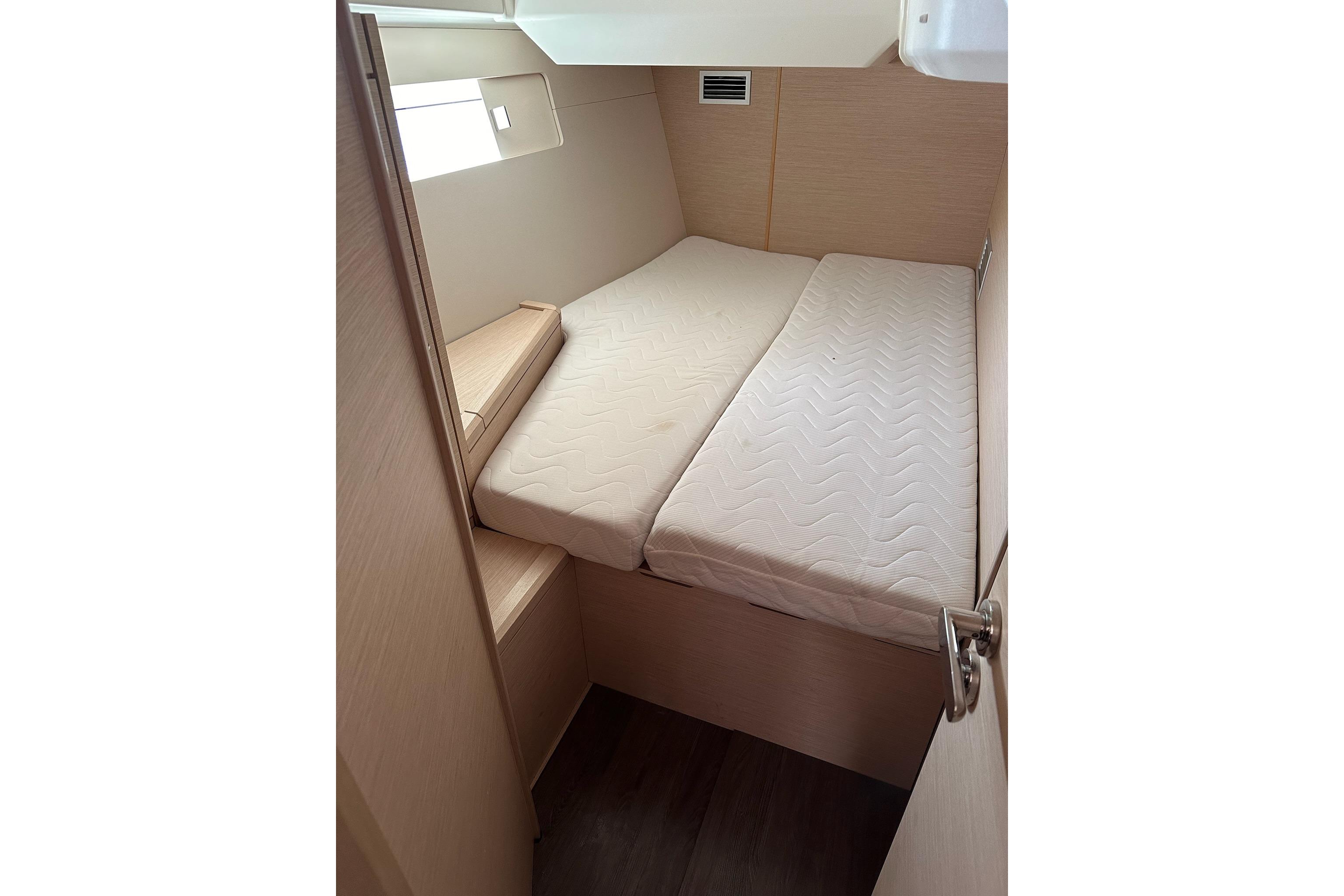 Interior cabin of 2018 Jeanneau 51 yacht with comfortable bedding.