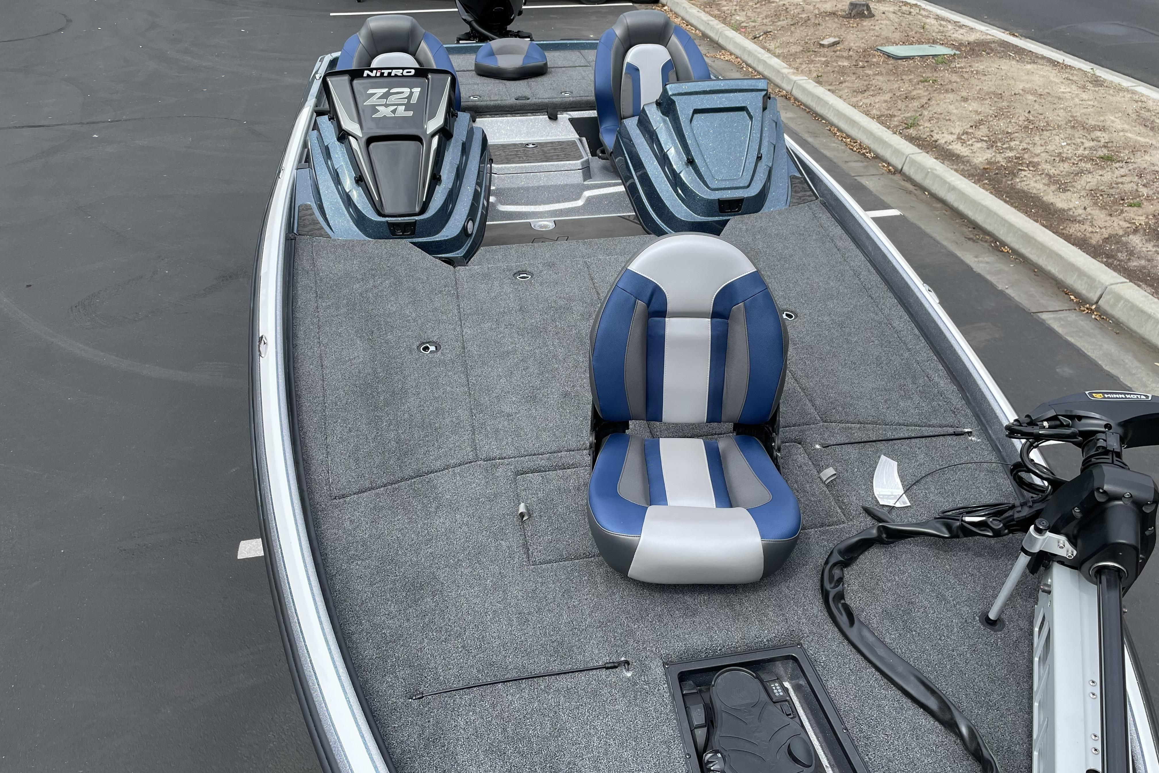 2026 Nitro Z21 XL boat with blue and gray seating, parked on asphalt.