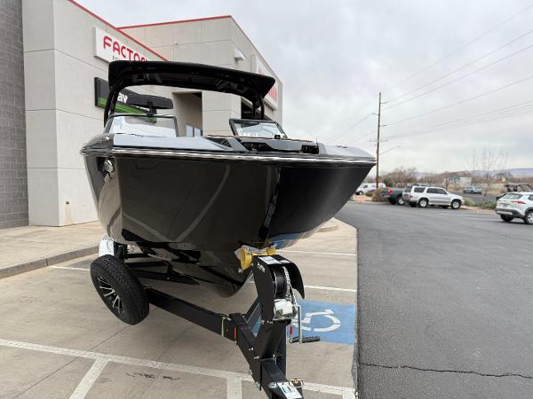 2025 Yamaha Boats 255XD on trailer outside dealership, showcasing sleek black design.