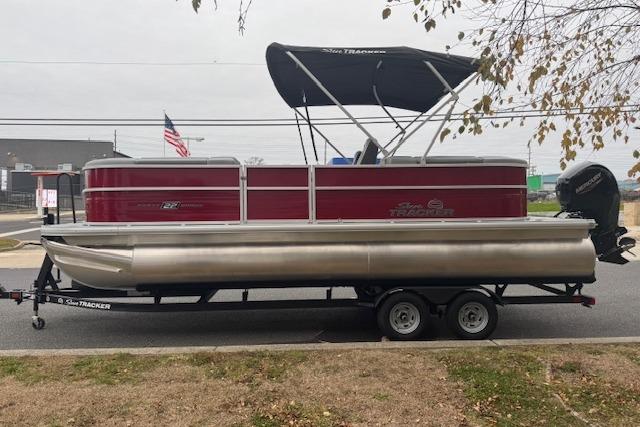 2026 Sun Tracker Party Barge 22 DLX pontoon boat on trailer, parked outdoors.
