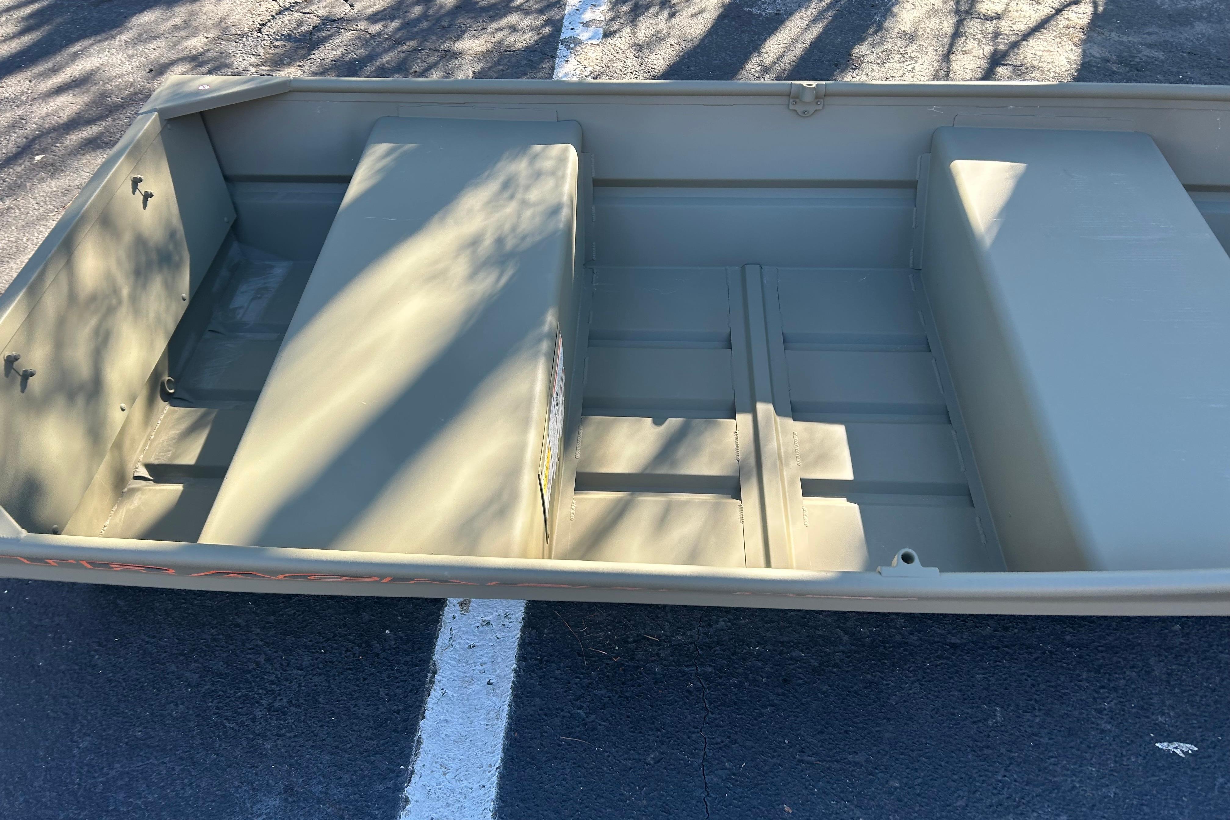 2026 Tracker Grizzly 12 Jon boat, empty interior view, parked on asphalt.