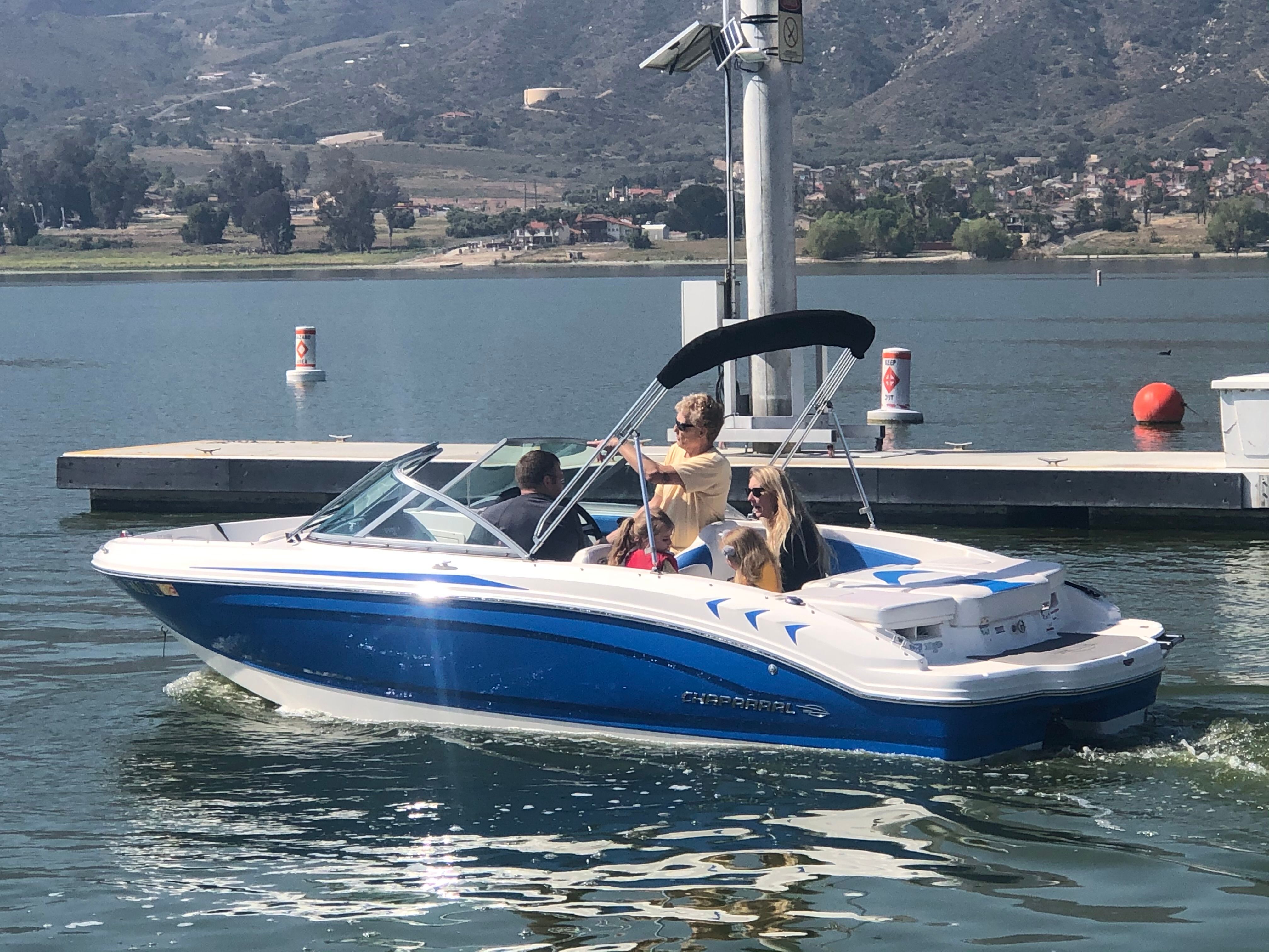 Chaparral 19 H2O Sport 2017 on a calm lake with passengers on board.