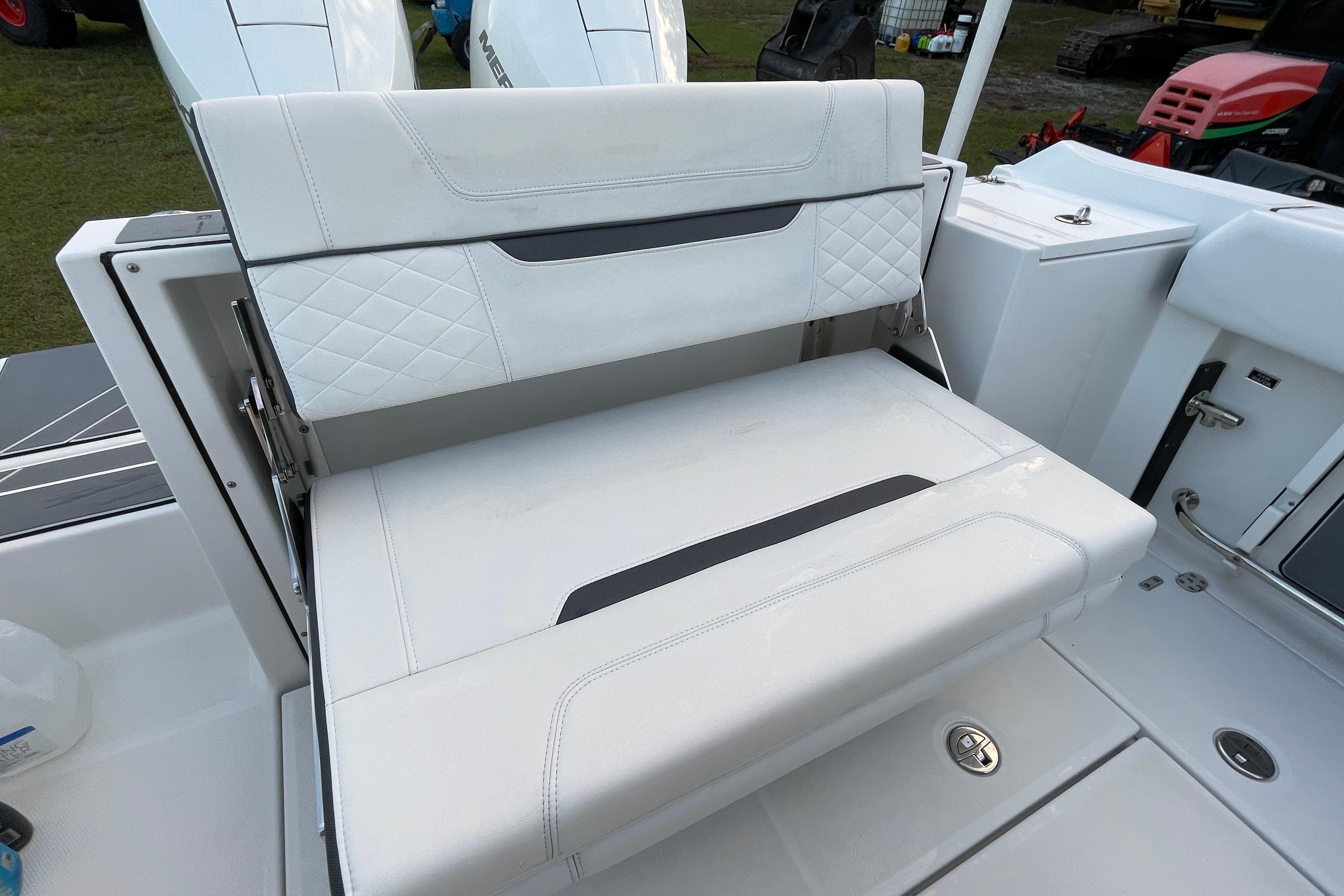 2022 Blackfin 252 CC boat with white cushioned seating and storage compartment.