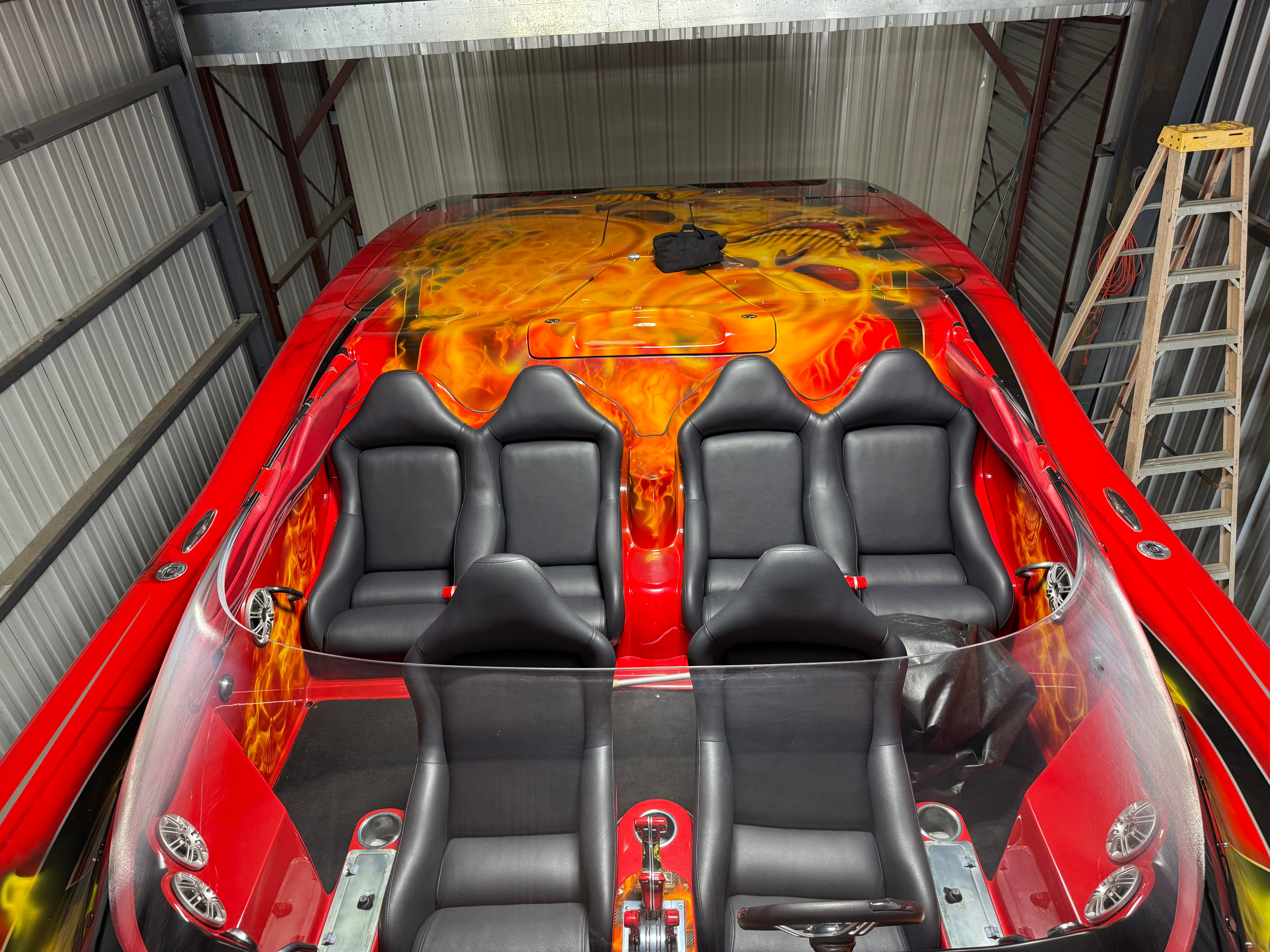 A 2010 MTI CAT with striking flame design and four black seats in a storage area.