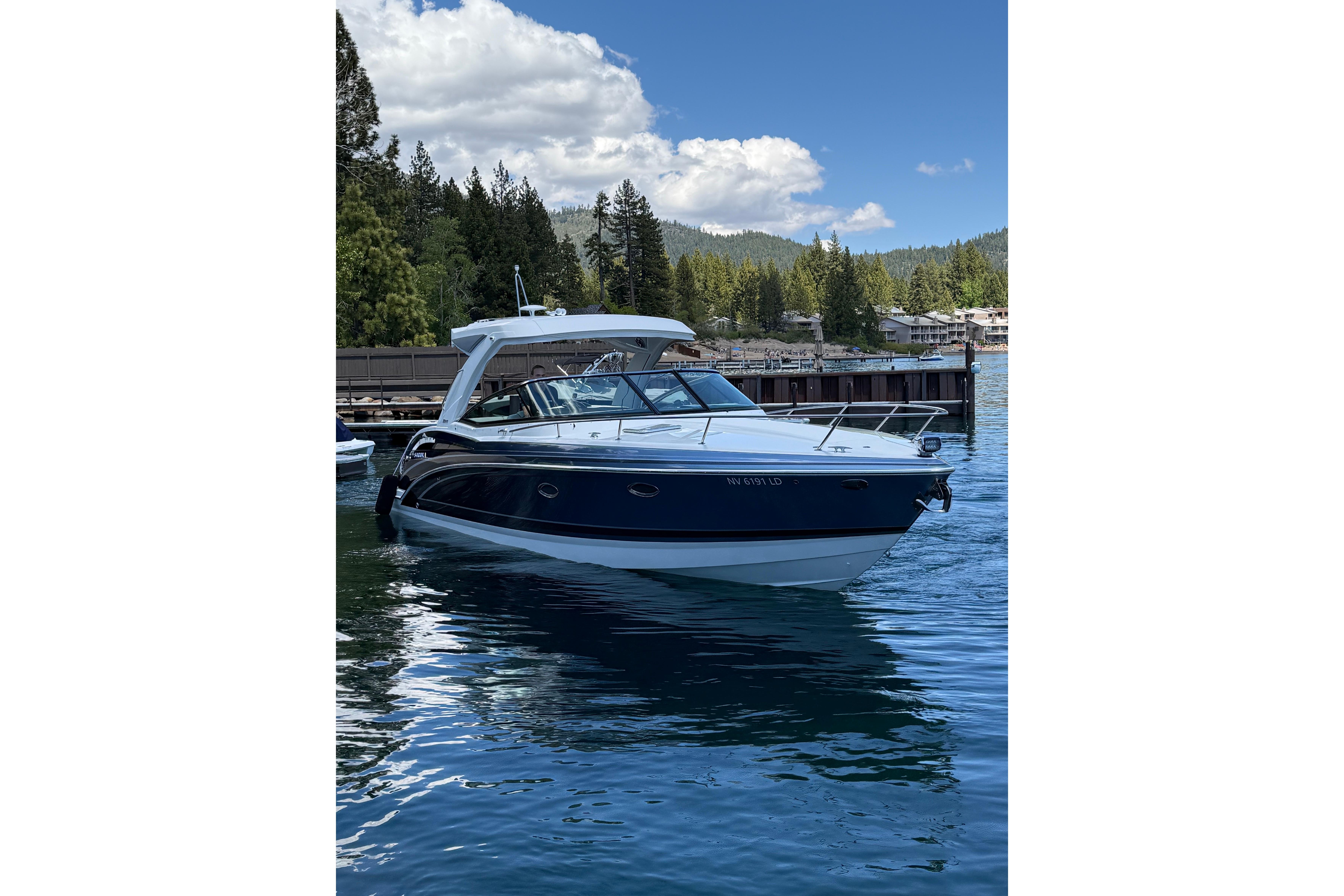 2021 Formula 350 Sun Sport boat docked on a serene lake with forested background.