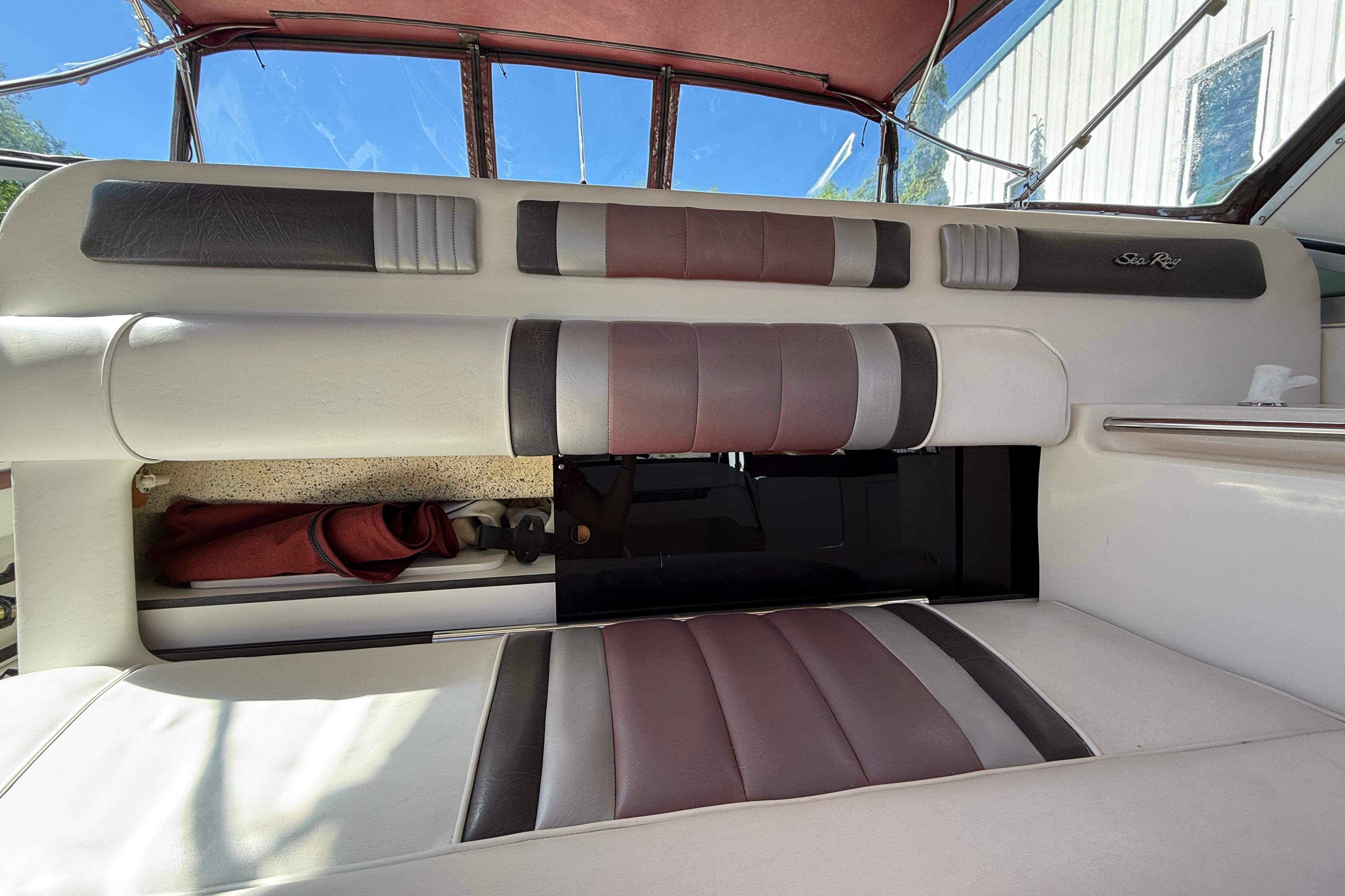 Interior seating of a 1990 Sea Ray 310 Express Cruiser with maroon and gray upholstery.