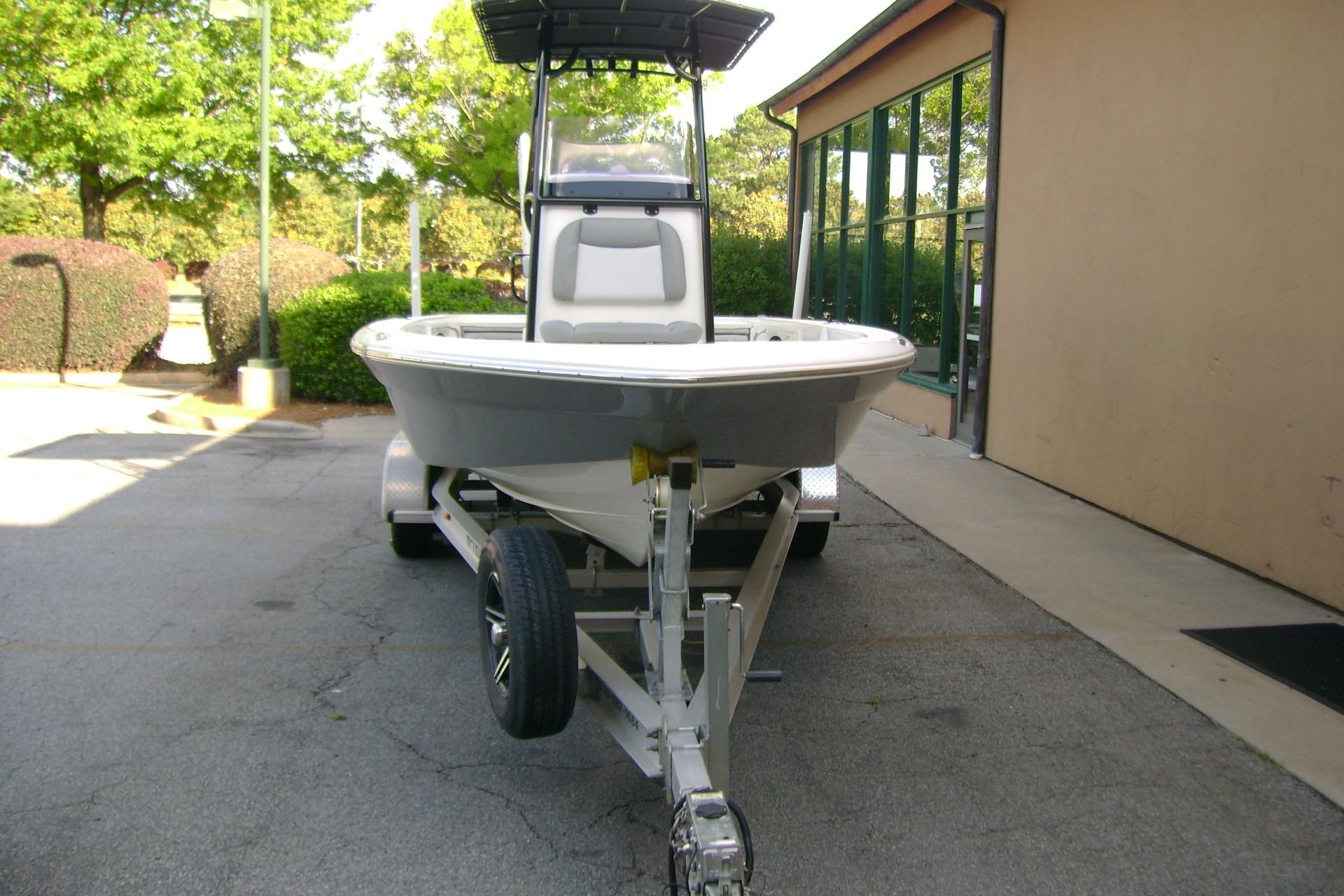 2022 NauticStar 227 XTS boat on trailer, parked outdoors near building.