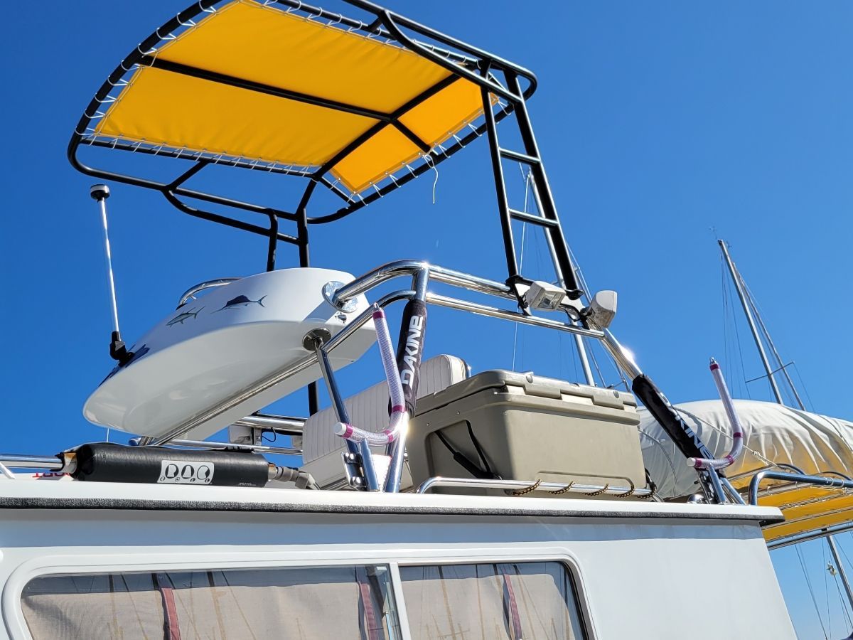A boat with a yellow sunshade and radar on the roof.